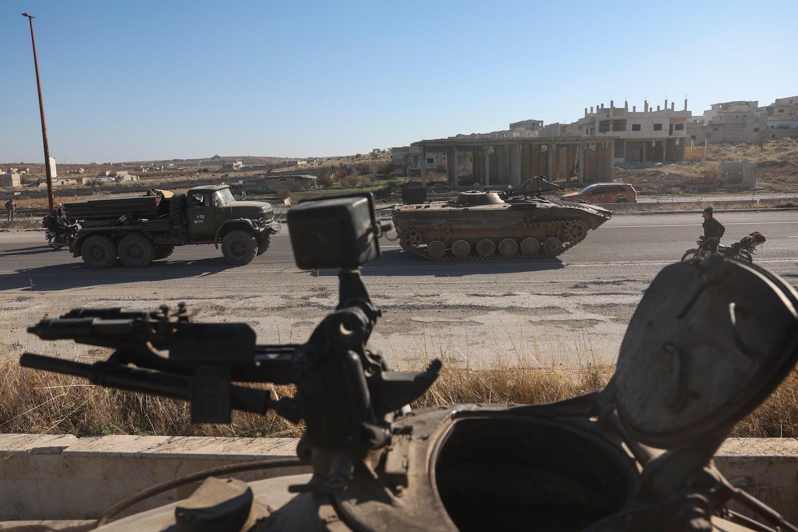 Opposition fighters ride military vehicles seized from the Syrian army Maarat al-Numan, southwest of Aleppo, Sunday, Dec. 1, 2024. Syrian opposition insurgency launched a campaign on Wednesday with a two-pronged attack on Aleppo and the countryside around Idlib.(AP Photo/Ghaith Alsayed)