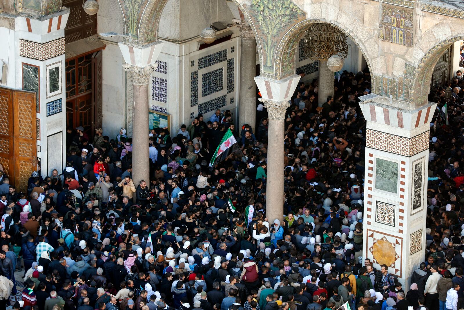 Syrians attend Friday prayers outside the 7th century Umayyad Mosque in Damascus, Syria, Friday, Dec. 13, 2024. (AP Photo/Omar Sanadiki)