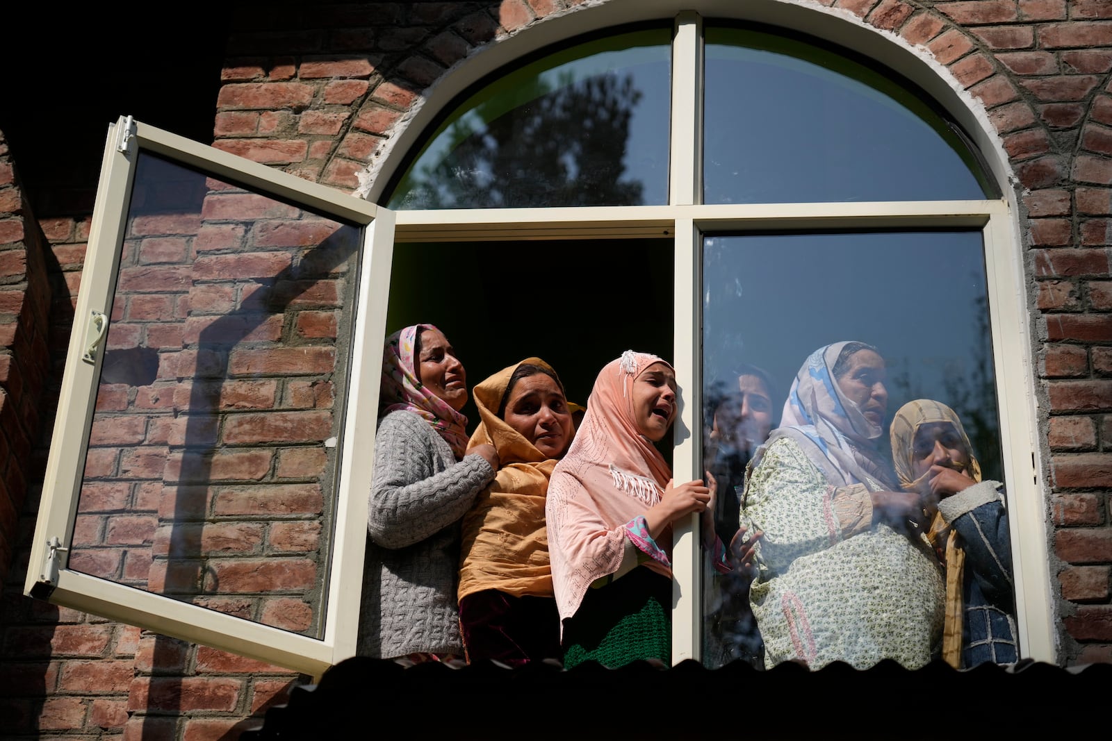 Relative and neighbors cry as they watch the funeral of Kashmiri doctor Shahnawaz who was among those killed when gunmen fired at people working on a strategic tunnel project in Indian-controlled Kashmir, at Nadigam village, southwest of Srinagar, Monday, Oct. 21, 2024. (AP Photo/Mukhtar Khan)