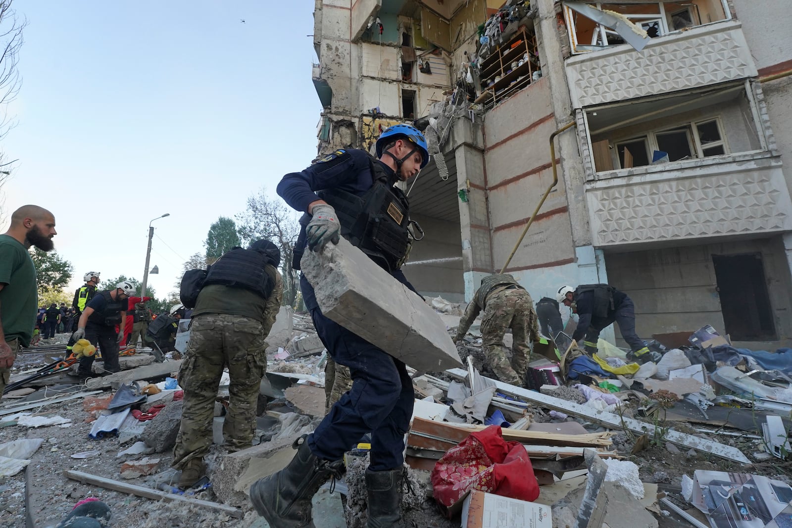 FILE - Emergency workers and soldiers try to shift the rubble and debris after a Russian attack that hit a residential building in Kharkiv, Ukraine, Tuesday Sept. 24, 2024. (AP Photo/Andrii Marienko, File)