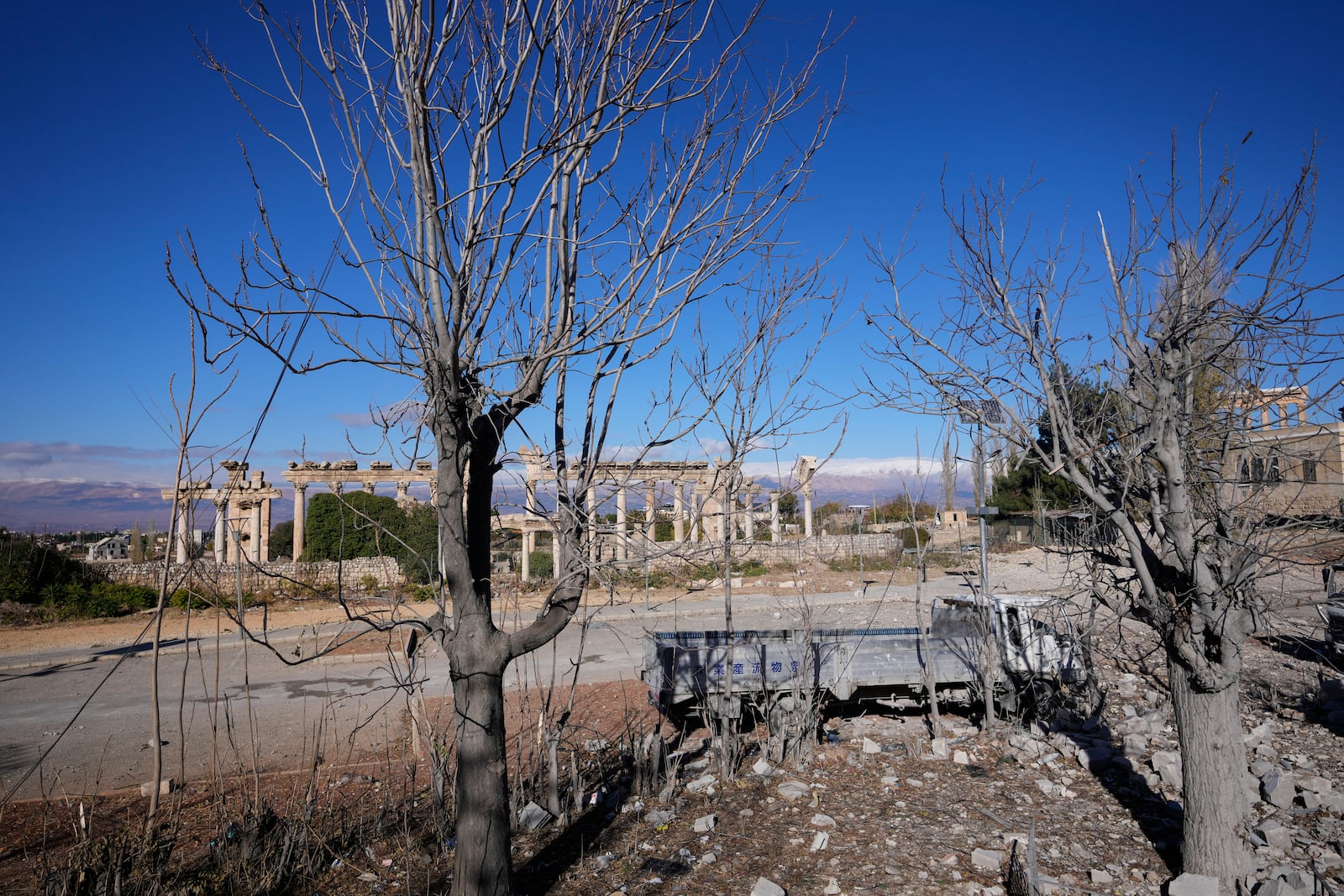 Damaged vehicles are seen in front of the Roman temples of Baalbek in eastern Lebanon, Thursday, Nov. 28, 2024. (AP Photo/Hassan Ammar)