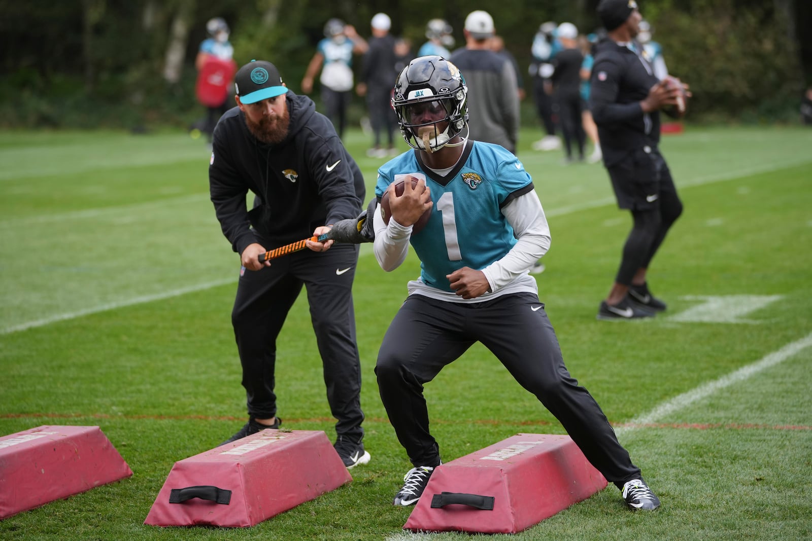 Jacksonville Jaguars NFL football running back Travis Etienne Jr. (1), right, practices at The Grove in Watford, England, Wednesday, Oct. 16, 2024. (AP Photo/Kin Cheung)