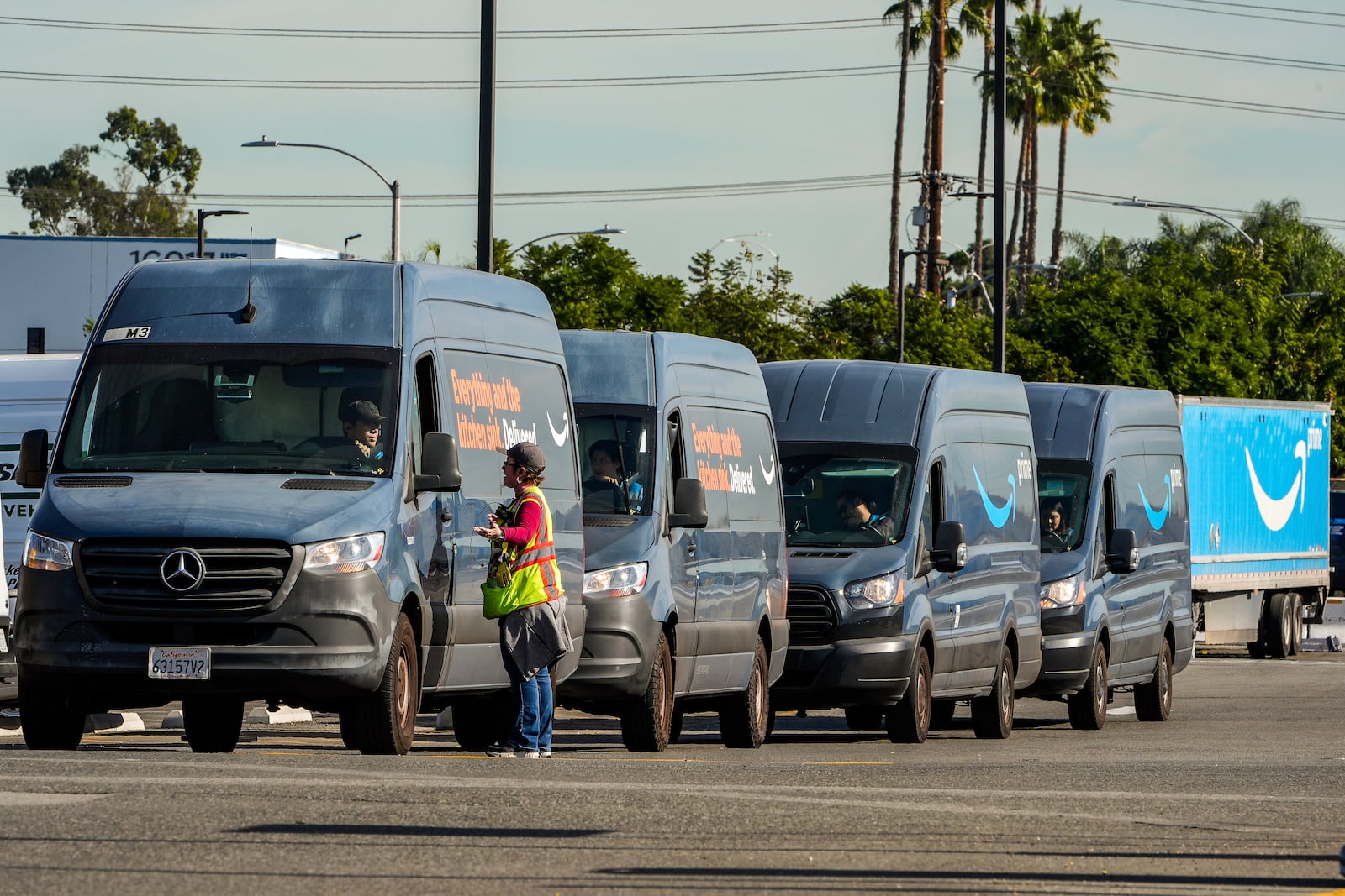 Amazon drivers wait in line before departing to deliver goods as Amazon workers picket outside the gates of an Amazon Fulfillment Center, Thursday, Dec. 19, 2024, in City of Industry, Calif. (AP Photo/Damian Dovarganes)