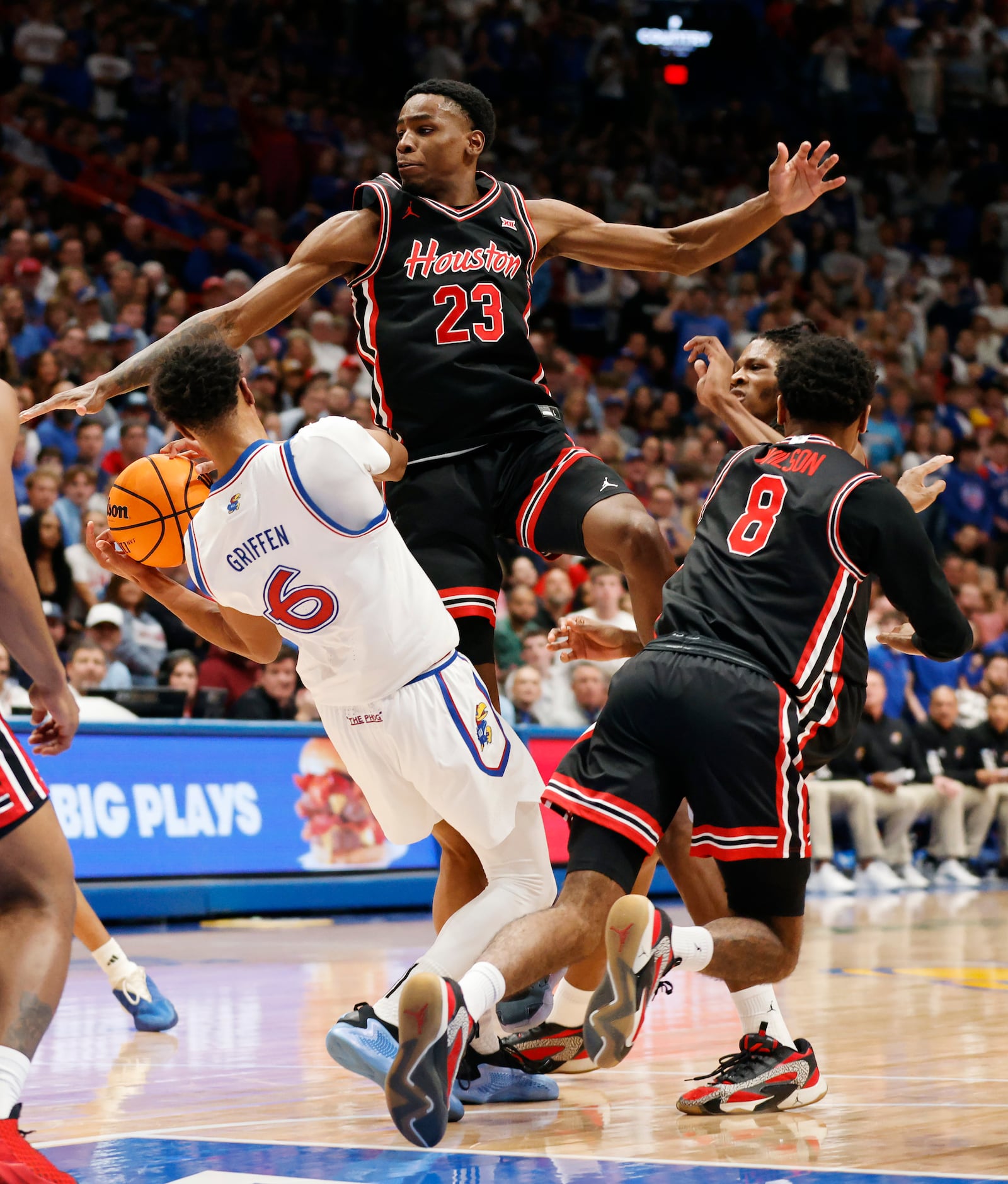 Kansas guard Rylan Griffen (6) attempts to pass as he is pressured by Houston guards Terrance Arceneaux (23) and Mylik Wilson (8) during the first half of an NCAA college basketball game, Saturday, Jan. 25, 2025, in Lawrence, Kan. (AP Photo/Colin E. Braley)