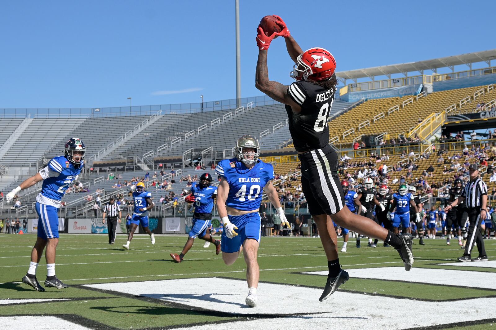 Team Aina tight end Andrew Ogletree (81), of Youngstown State, catches a pass in the end zone for a touchdown in front of Team Kai linebacker Drew White (40), of Notre Dame, during the first half of the Hula Bowl NCAA college football game, Saturday, Jan. 15, 2022, in Orlando, Fla. (AP Photo/Phelan M. Ebenhack)