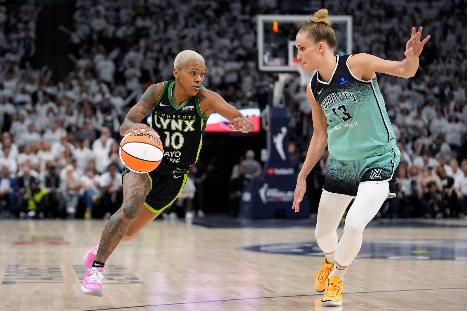 Minnesota Lynx guard Courtney Williams (10) drives past New York Liberty forward Leonie Fiebich (13) during the second half in Game 3 of a WNBA basketball final playoff series, Wednesday, Oct. 16, 2024, in Minneapolis. (AP Photo/Abbie Parr)