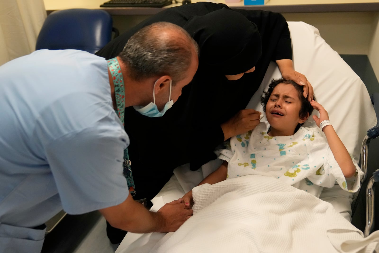 FILE - Palestinian girl Halima Abou Yassine, 7, who was brought to Lebanon from Gaza for treatment after an Israeli strike left her near death with a gaping wound in her skull, cries as she lies on a hospital bed ahead of a surgery on her head at the American University of Beirut Medical Center (AUBMC), in Beirut, Lebanon, Monday, July 15, 2024. (AP Photo/Hussein Malla, File)