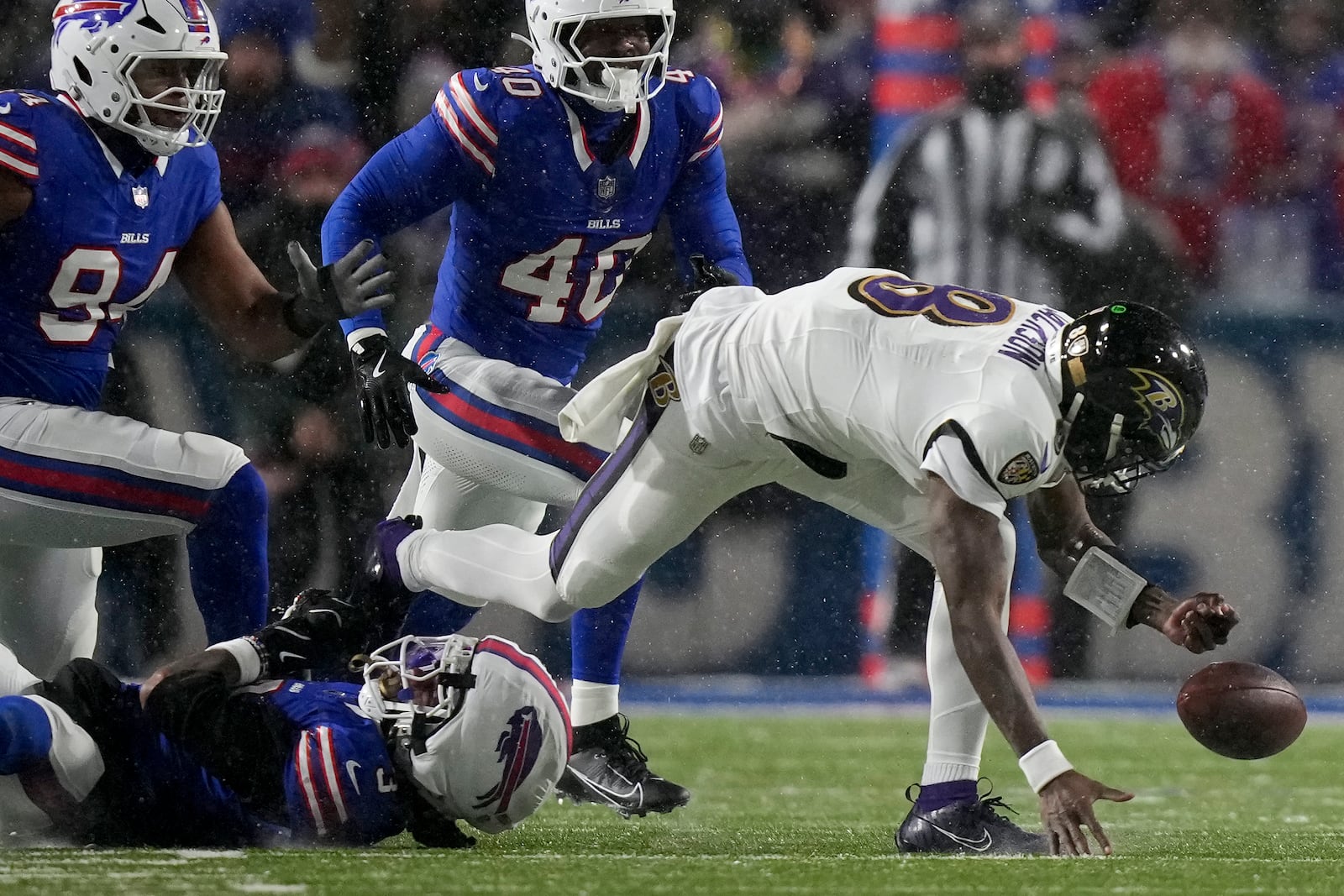 Baltimore Ravens quarterback Lamar Jackson (8) fumbles the ball as he is tackled by Buffalo Bills safety Damar Hamlin (3) during the second quarter of an NFL divisional playoff football game, Sunday, Jan. 19, 2025, in Orchard Park, N.Y. (AP Photo/Frank Franklin II)