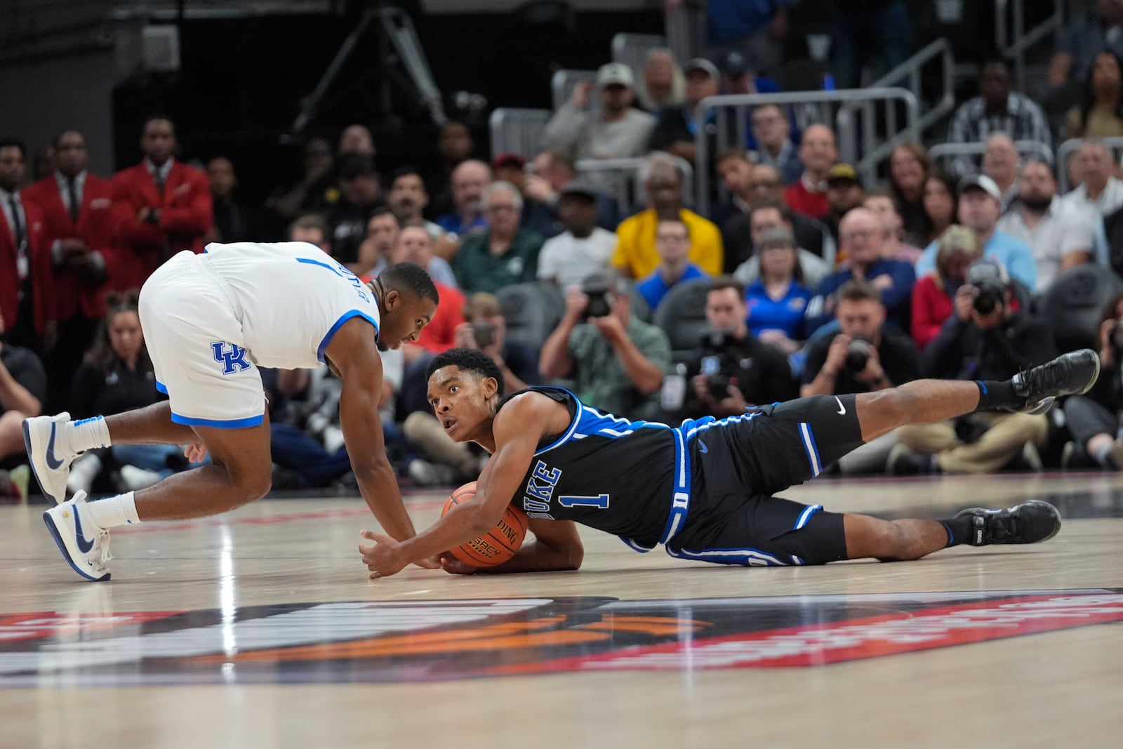 Duke guard Caleb Foster (1) and Kentucky guard Lamont Butler (1) dive for a loose ball during the first half of an NCAA college basketball game, Tuesday, Nov. 12, 2024, in Atlanta. (AP Photo/John Bazemore )