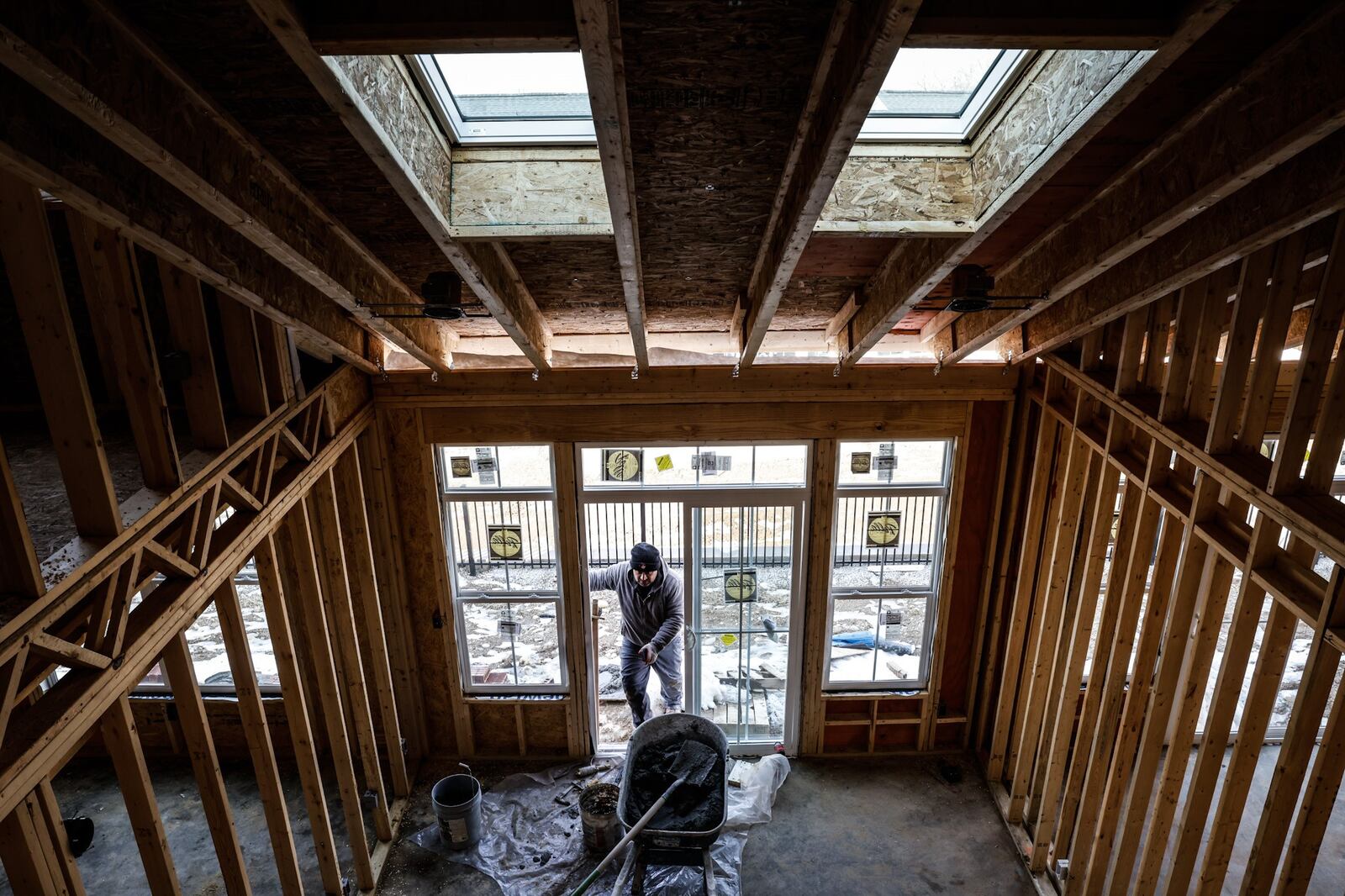 A bricklayer works outside on a warm February day at the Cottages of Beavercreek, a Charles Simms Development project. Higher housing costs contributed to inflation. JIM NOELKER/STAFF