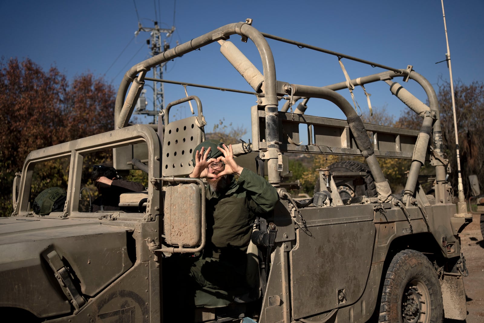 An Israeli soldier gestures from his vehicle in northern Israel, near the border with Lebanon, during a ceasefire, Tuesday, Dec. 3, 2024. (AP Photo/Maya Alleruzzo)