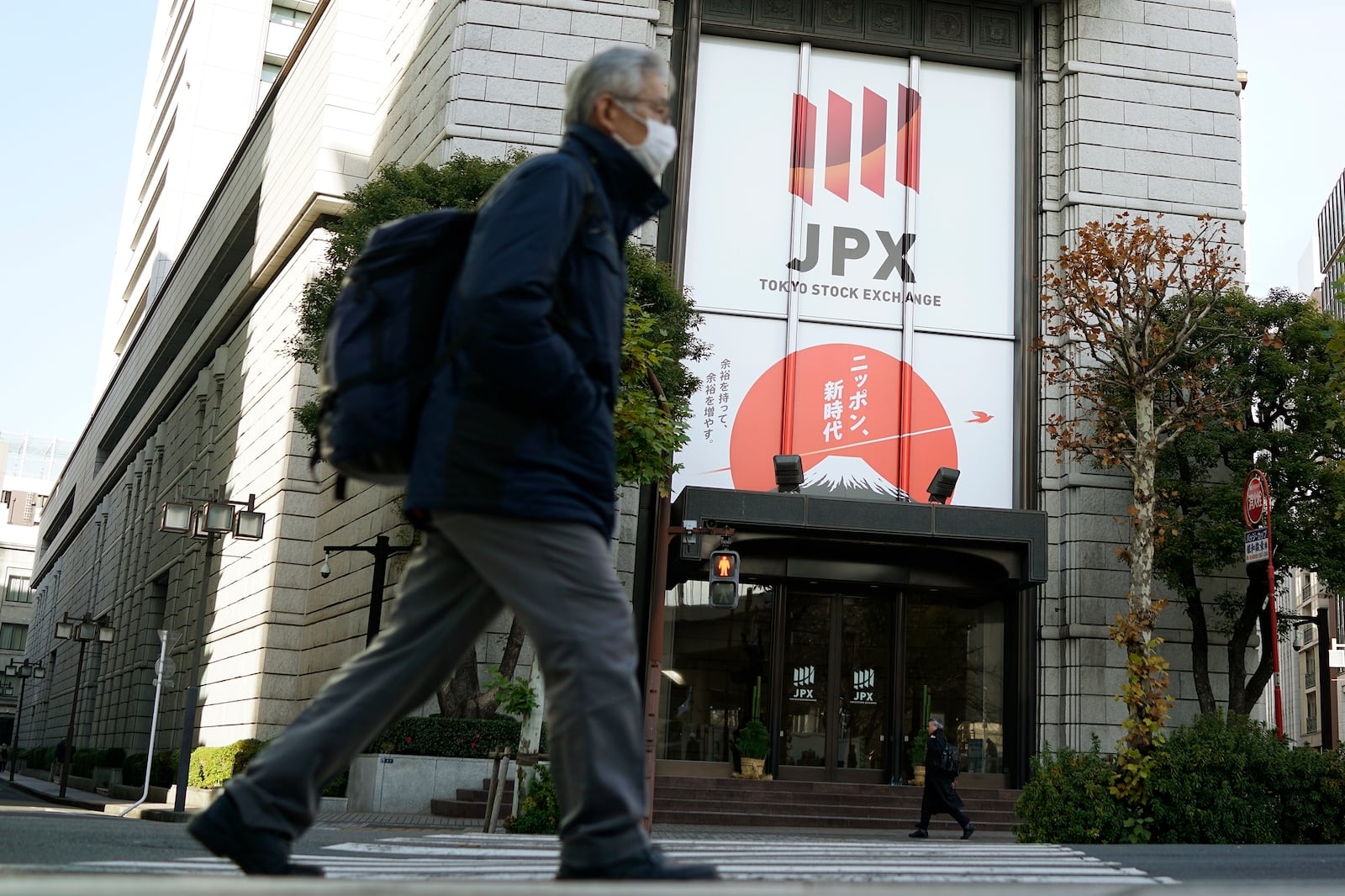 FILE - People walk in front of Tokyo Stock Exchange building in Tokyo, Dec. 25, 2024. (AP Photo/Eugene Hoshiko, File)