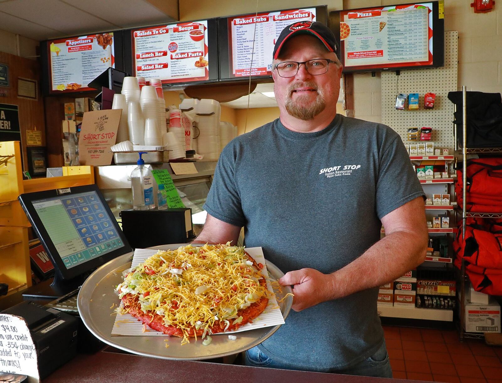 Rob Koons, co-owner of Short Stop Italian Restaurant, with a fresh Taco Pizza. BILL LACKEY/STAFF