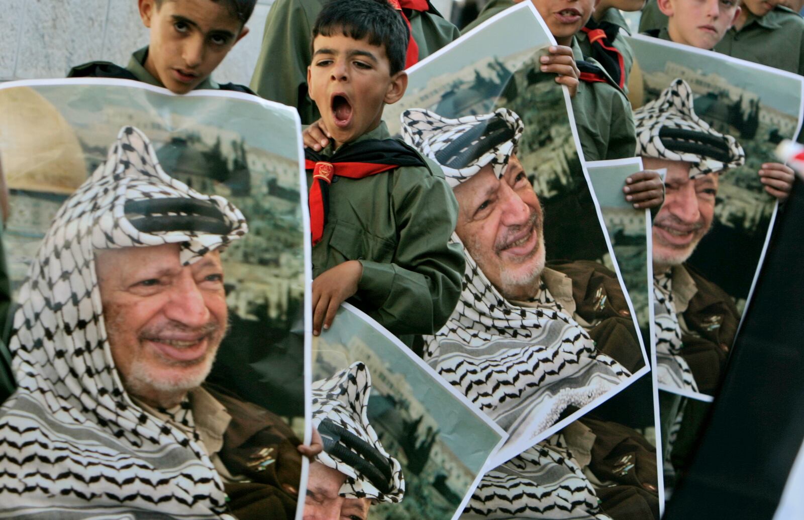 FILE - Palestinian boys hold portraits of late leader Yasser Arafat during a ceremony to commemorate the Nakba, or the catastrophe, the Arabic term used to describe the uprooting of hundreds of thousands of Palestinians with the 1948 creation of the state of Israel, in the West Bank village of Beit Anan, near Ramallah May 10, 2008. (AP Photo/Muhammed Muheisen, File)