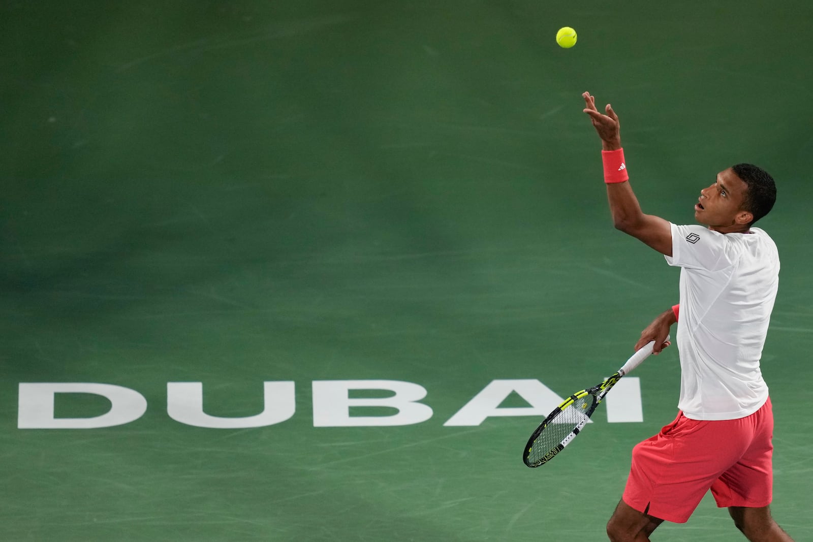 Felix Auger-Aliassime of Canada serves to Stefanos Tsitsipas of Greece during the men's singles final match of Dubai Duty Free Tennis Championship in Dubai, United Arab Emirates, on Saturday, March 1, 2025. (AP Photo/Altaf Qadri)