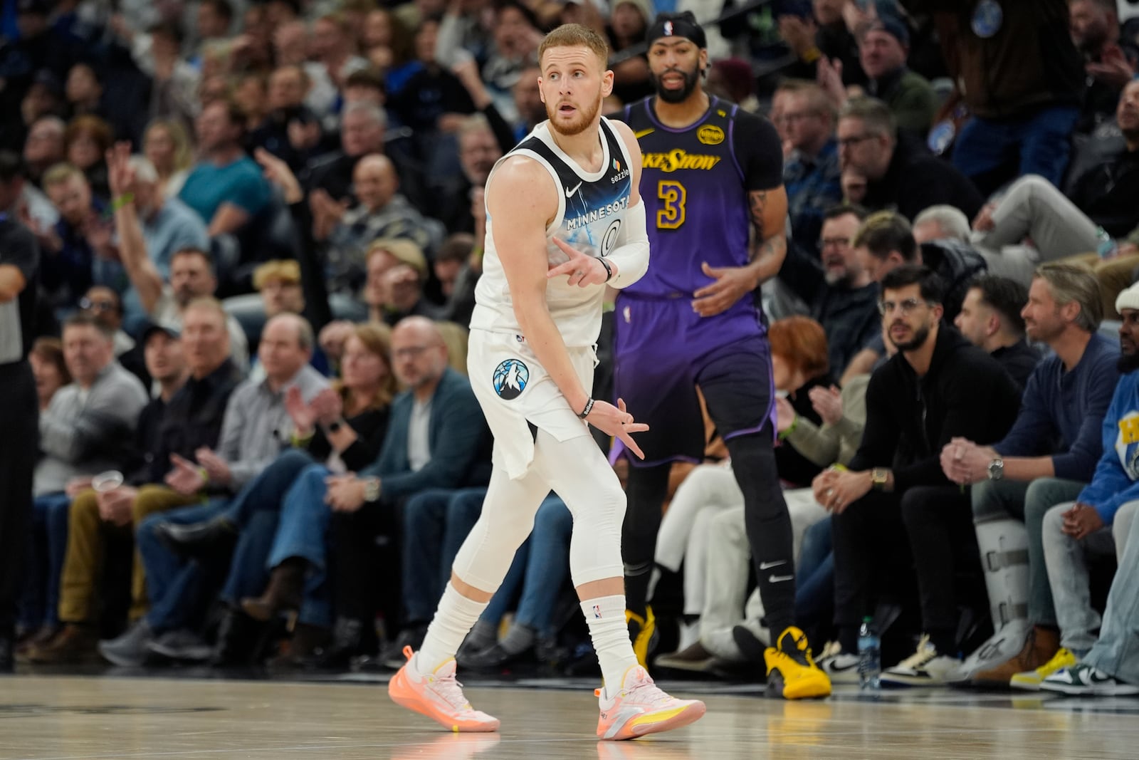 Minnesota Timberwolves guard Donte DiVincenzo (0) reacts next to Los Angeles Lakers forward Anthony Davis (3) after making a 3-point shot during the first half of an NBA basketball game, Monday, Dec. 2, 2024, in Minneapolis. (AP Photo/Abbie Parr)