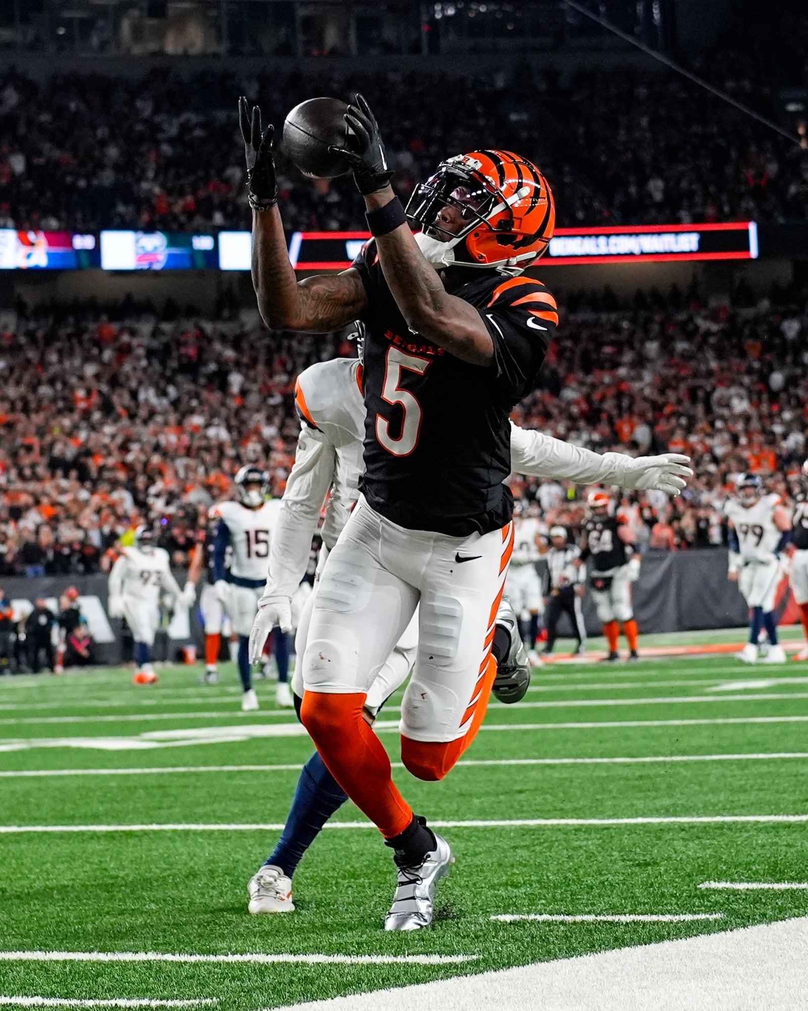 Cincinnati Bengals wide receiver Tee Higgins (5) makes a catch in front of Denver Broncos cornerback Riley Moss (21) during overtime of an NFL football game in Cincinnati, Saturday, Dec. 28, 2024. (AP Photo/Carolyn Kaster)