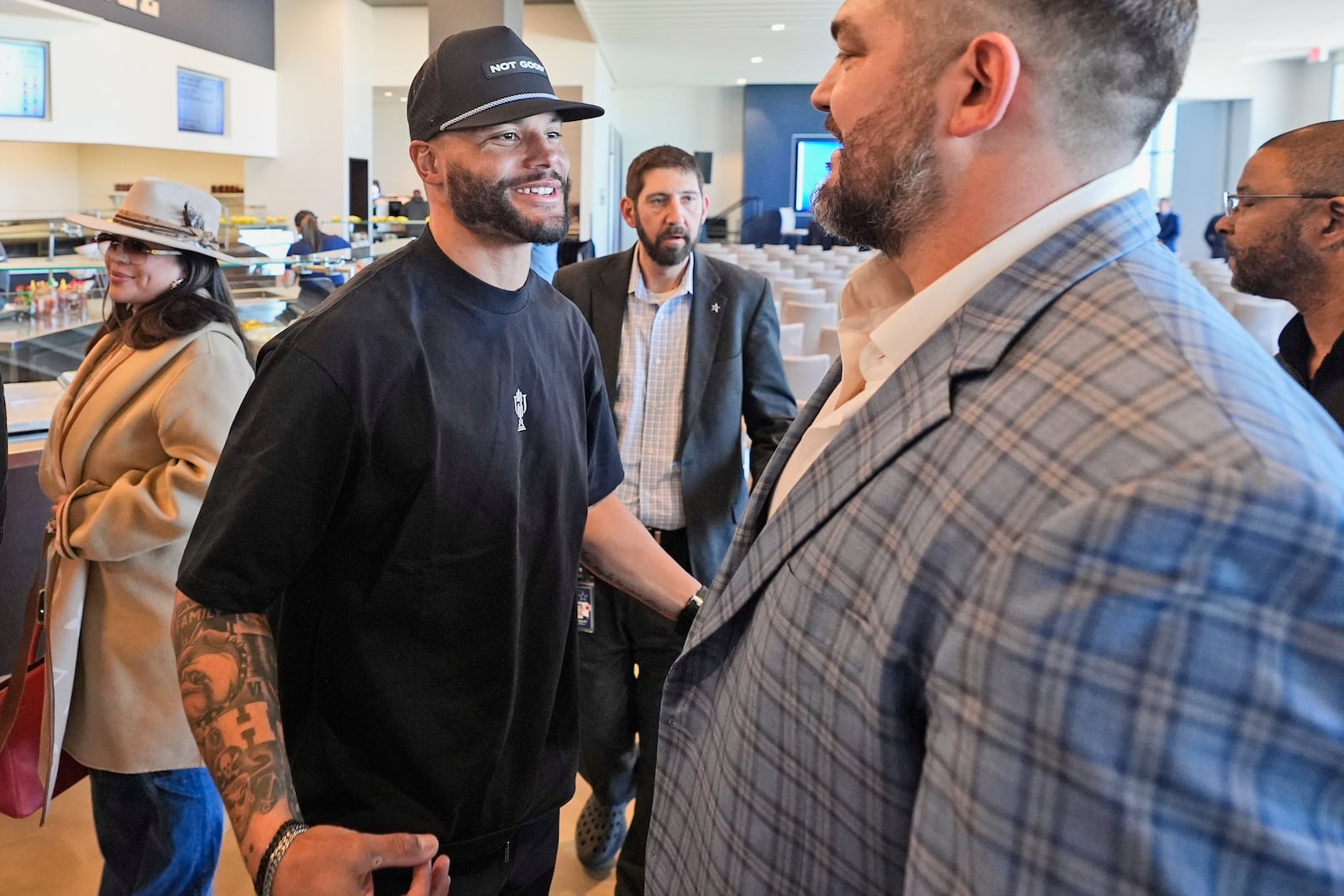 Dallas Cowboys quarterback Dak Prescott, left, greets lineman Zach Martin after Martin announced his retirement during an NFL football press conference at the team's headquarter in Frisco, Texas, Wednesday, March 5, 2025. (AP Photo/LM Otero)