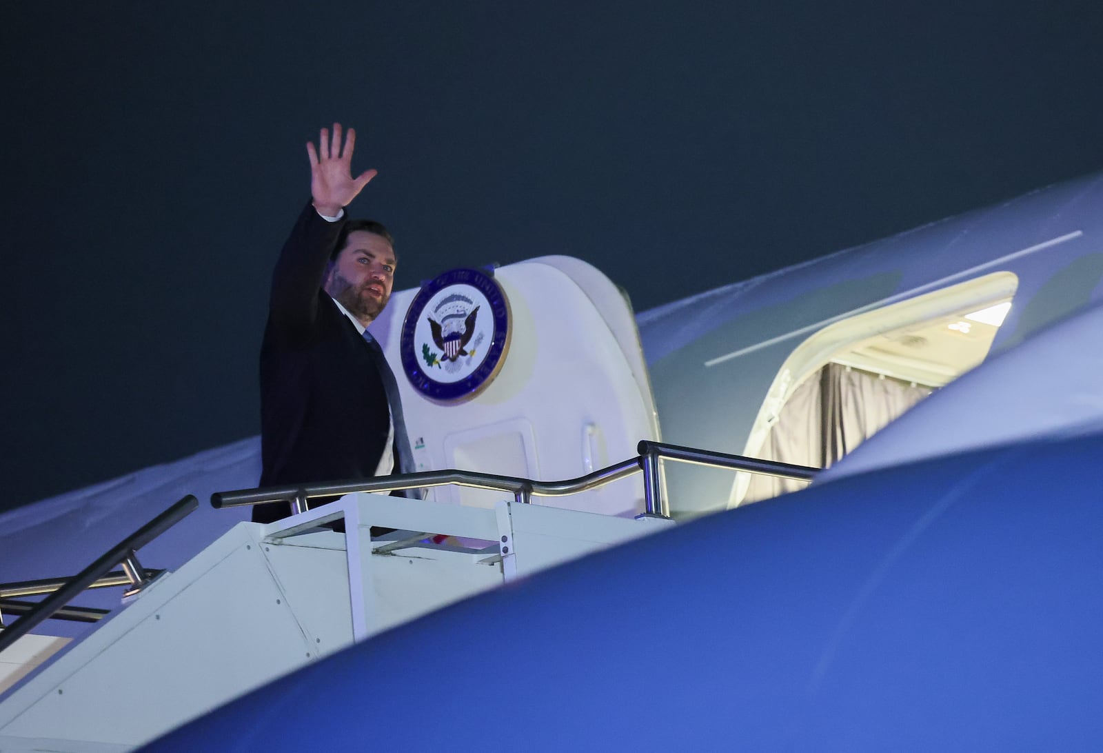 U.S. Vice President JD Vance waves as he boards Air Force Two for travel back to Washington from Munich International Airport in Munich, Germany, Friday, Feb.14, 2025. (Leah Millis/Pool Photo via AP)