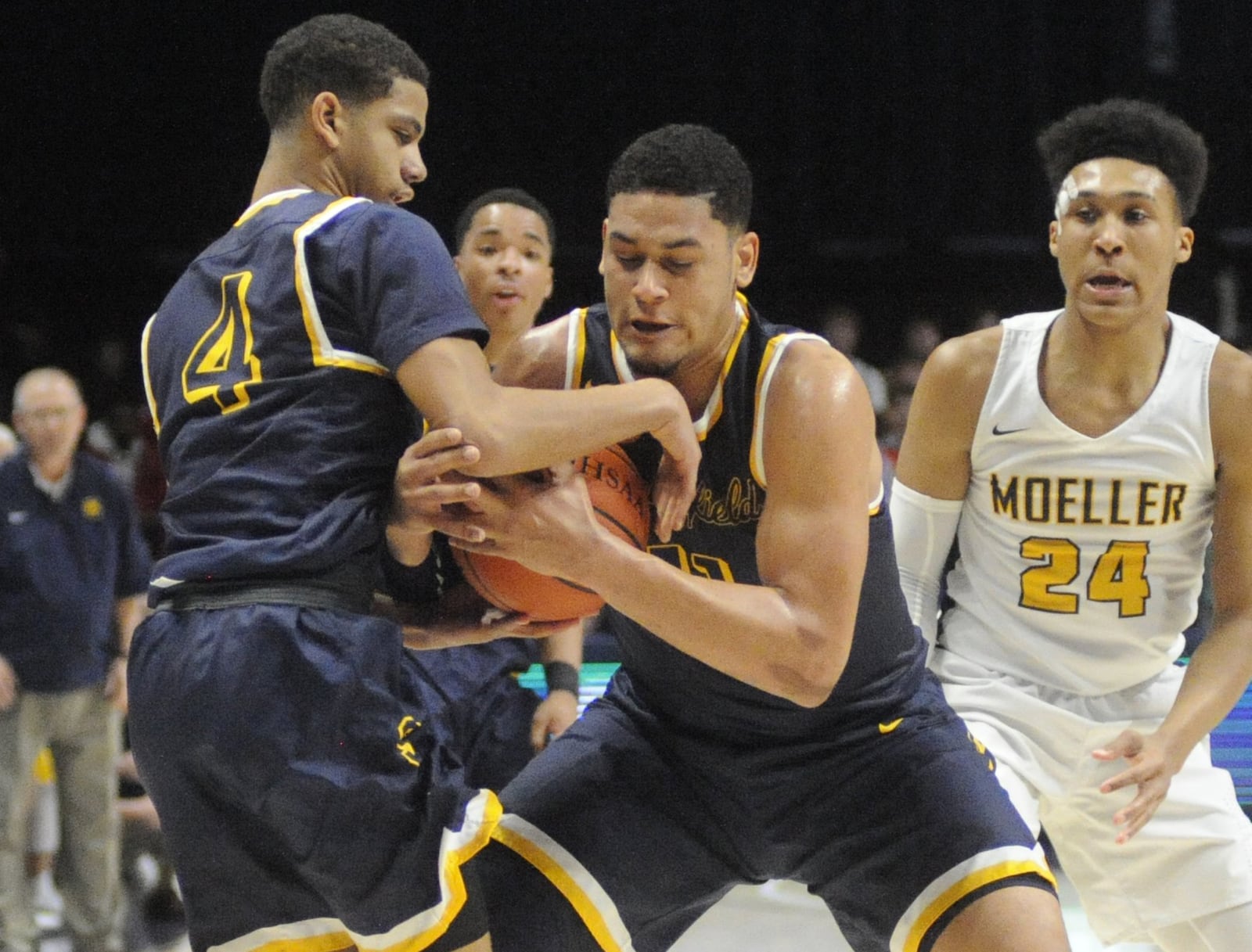 Leonard Taylor (middle) and David Sanford secure a rebound. Moeller defeated Springfield 65-44 in a boys high school basketball D-I regional semifinal at Xavier University’s Cintas Center in Cincinnati on Wednesday, March 14, 2018. MARC PENDLETON / STAFF