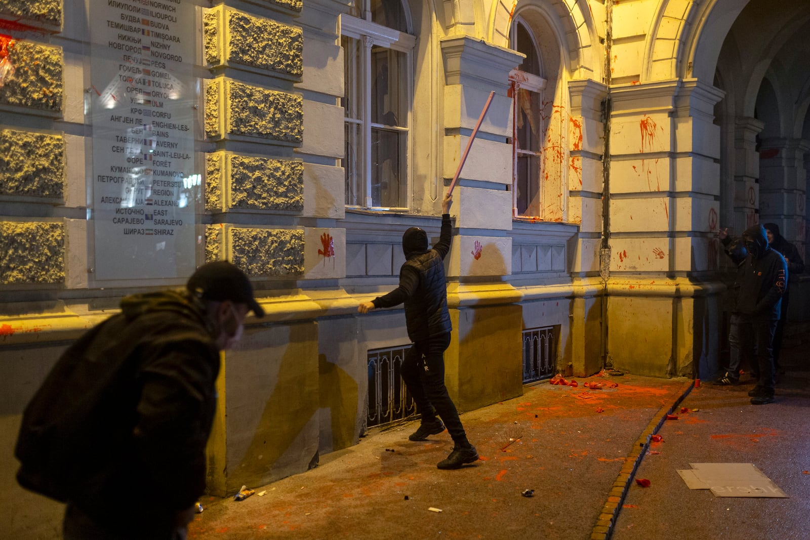 A rioter breaks a window on the City Hall building during a protest in Novi Sad, Serbia, Tuesday, Nov. 5, 2024. (AP Photo/Marko Drobnjakovic)