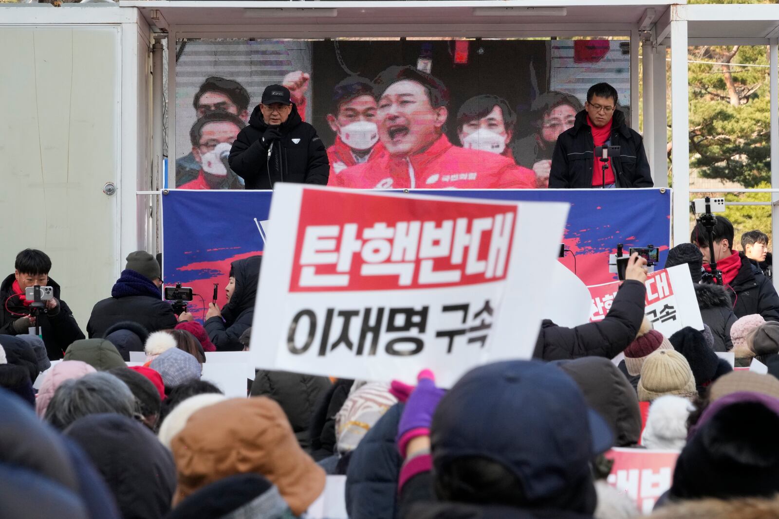 Supporters of impeached South Korean President Yoon Suk Yeol stage a rally against his impeachment near the Seoul Central District Court in Seoul, South Korea, Tuesday, Dec. 17, 2024. The signs read "Oppose the impeachment and Arrest opposition Democratic Party leader Lee Jae-myung." (AP Photo/Ahn Young-joon)