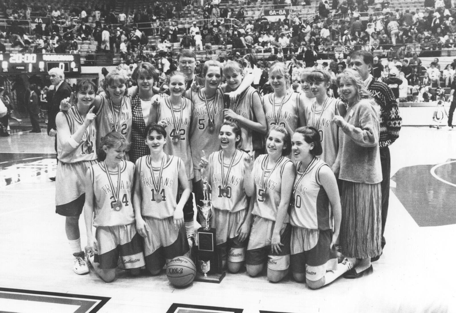 Members of Southeastern's 1996 girls basketball state championship team pose for a photo moments after winning their title. Contributed photo.