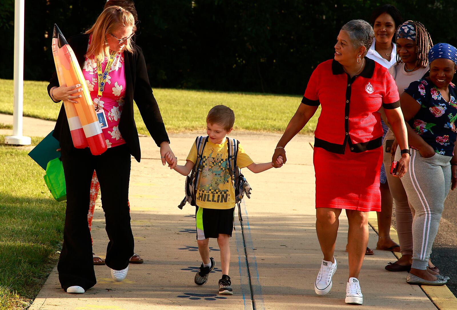 A student holds hands with the staff at Fulton Elementary as they walk into school for the first day Wednesday, August 14, 2024. BILL LACKEY/STAFF