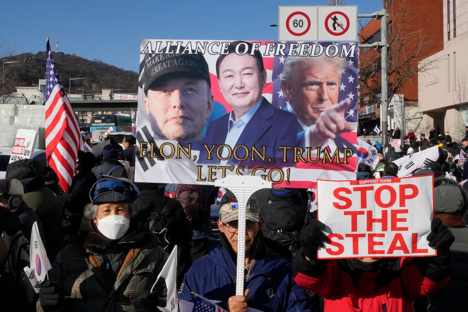 Supporters of impeached South Korean President Yoon Suk Yeol attend with a banner showing portraits of him, center, US President-elect Donald Trump and Tesla and SpaceX CEO Elon Musk, left, during a rally to oppose his impeachment near the presidential residence in Seoul, South Korea, Friday, Jan. 10, 2025. (AP Photo/Ahn Young-joon)