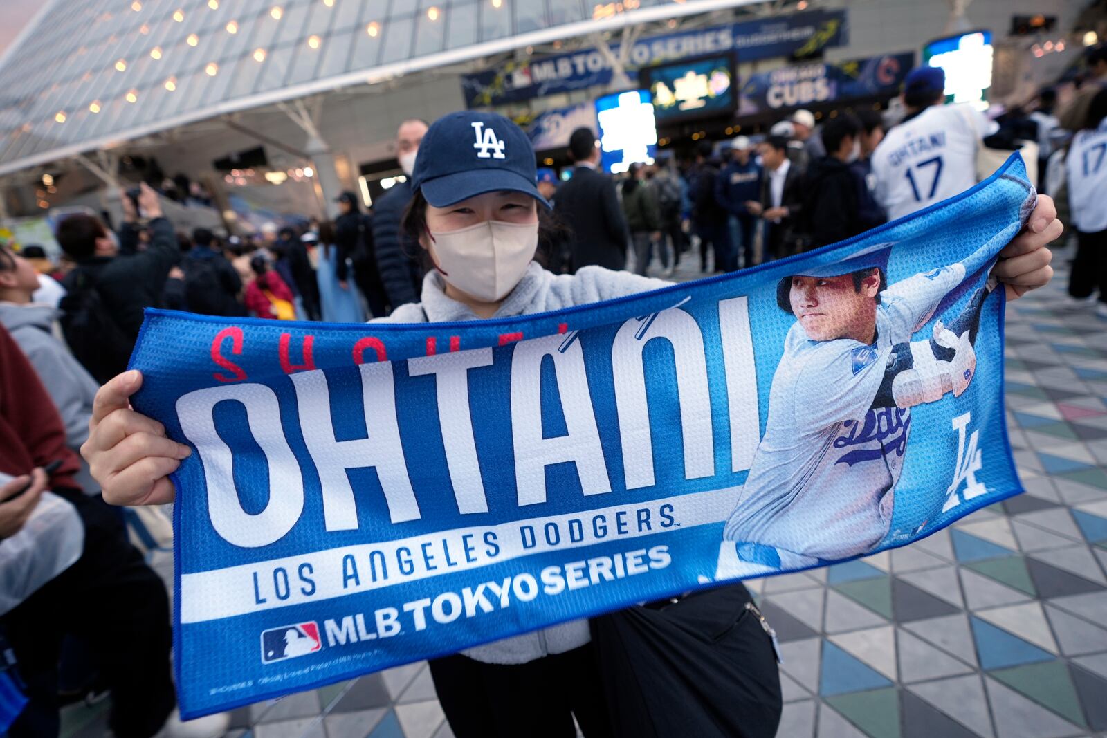 A fan shows an image of Los Angeles Dodgers' Shohei Ohtani, before an MLB Japan Series baseball game between the Los Angeles Dodgers and the Chicago Cubs at Tokyo Dome, in Tokyo, Tuesday, March 18, 2025. (AP Photo/Shuji Kajiyama)