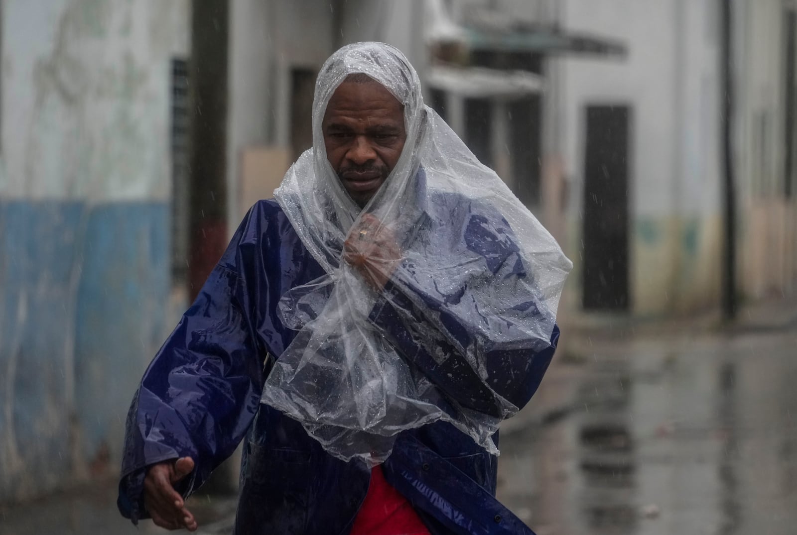 A man walks through the wind and rain brought by Hurricane Rafael in Havana, Cuba, Wednesday, Nov. 6, 2024. (AP Photo/Ramon Espinosa)