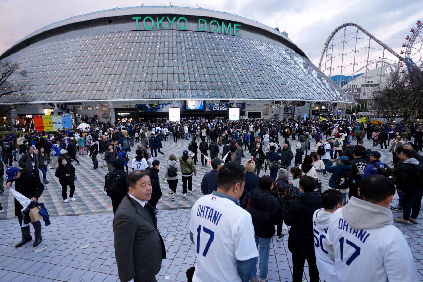 People walk outside Tokyo Dome, before an MLB Japan Series baseball game between the Los Angeles Dodgers and the Chicago Cubs, in Tokyo, Tuesday, March 18, 2025. (AP Photo/Shuji Kajiyama)