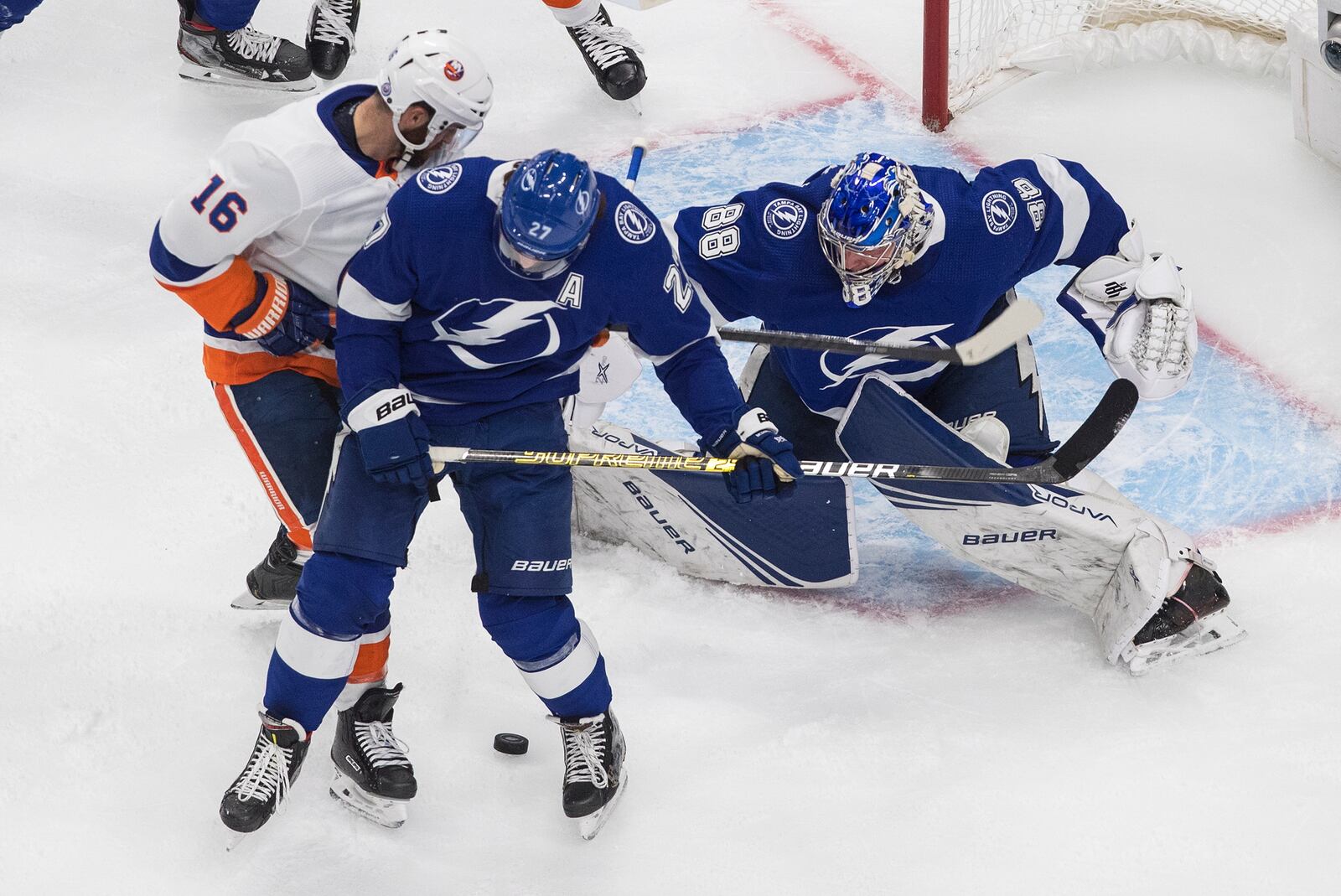 Tampa Bay Lightning goalie Andrei Vasilevskiy (88) makes a save as New York Islanders' Andrew Ladd (16) and Lightning's Ryan McDonagh (27) battle in front during the first period of Game 2 of the NHL hockey Eastern Conference final, Wednesday, Sept. 9, 2020, in Edmonton, Alberta. (Jason Franson/The Canadian Press via AP)