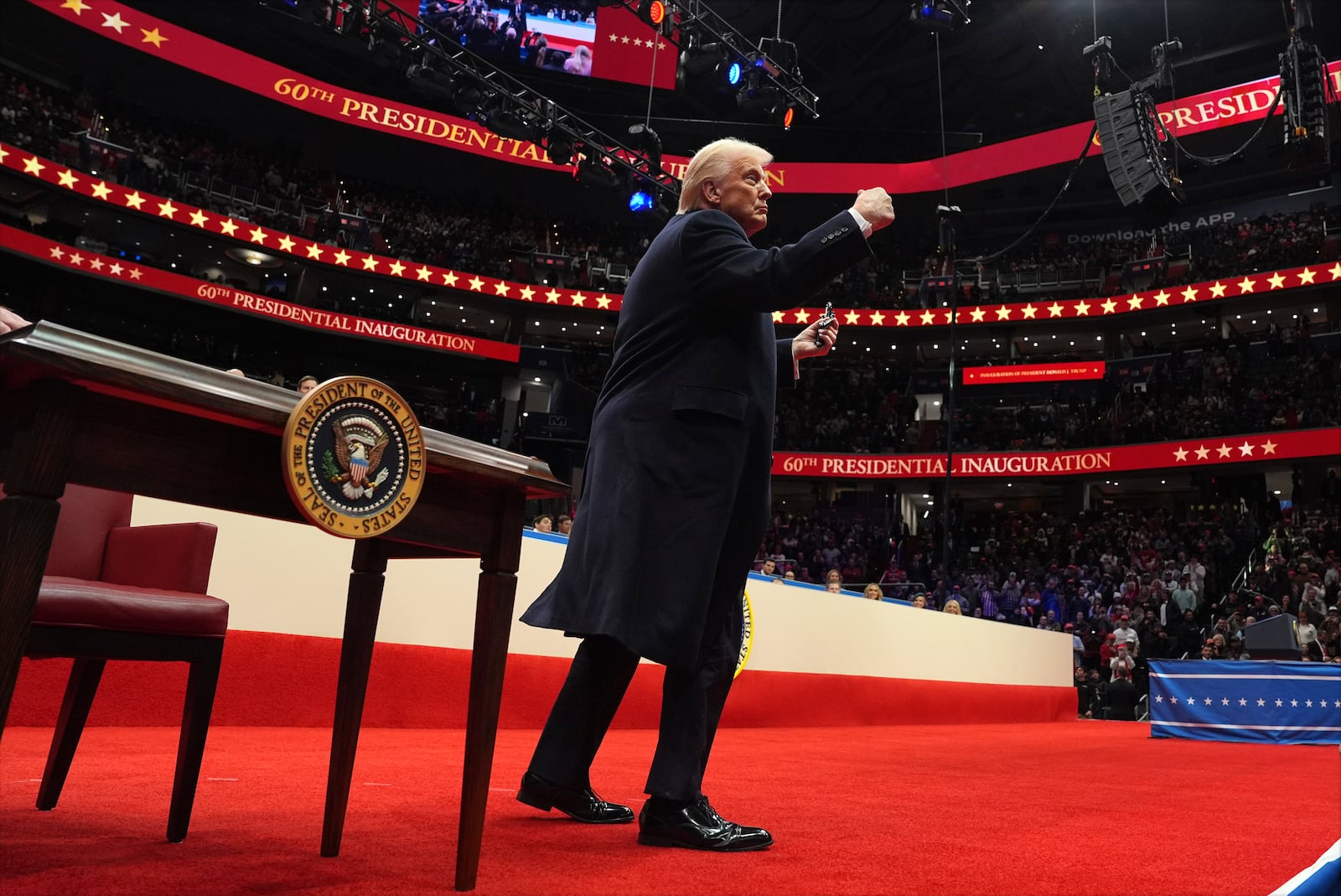 President Donald Trump throws pens he used to sign executive orders to the crowd as he attends an indoor Presidential Inauguration parade event at Capital One Arena, Monday, Jan. 20, 2025, in Washington. (AP Photo/Evan Vucci)