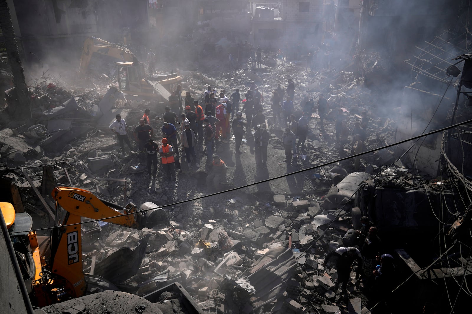 An excavator sifts through the rubble as rescue workers search for victims at the site of Israeli airstrikes that destroyed buildings, facing the city's main government hospital in a densely-populated neighborhood, in southern Beirut, Lebanon, Tuesday, Oct. 22, 2024. (AP Photo/Hussein Malla)