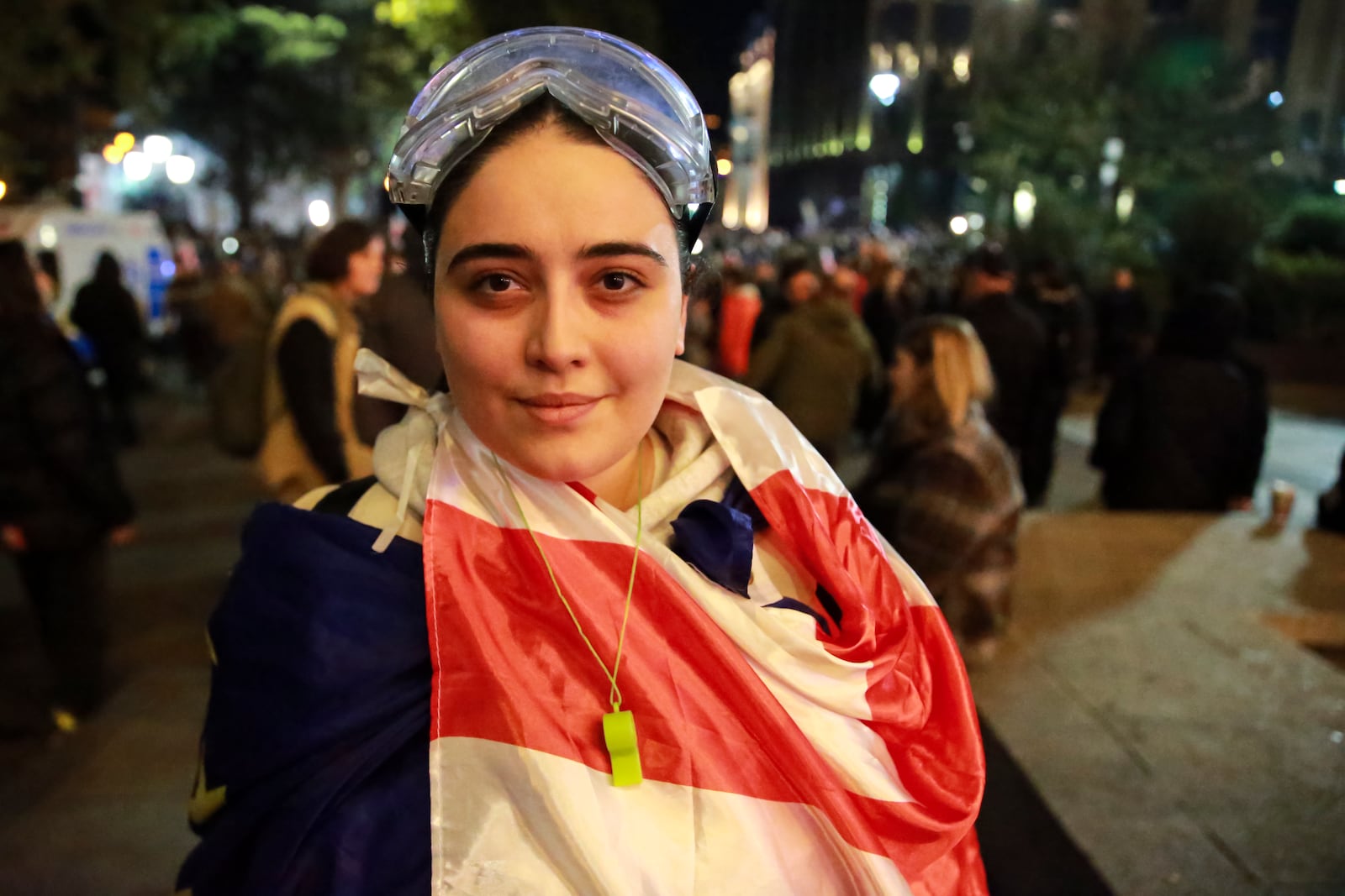 A young woman with a Georgian national flag looks at a photographer during an opposition protest against the results of the parliamentary election in Tbilisi, Georgia, Monday, Oct. 28, 2024. (AP Photo/Zurab Tsertsvadze)