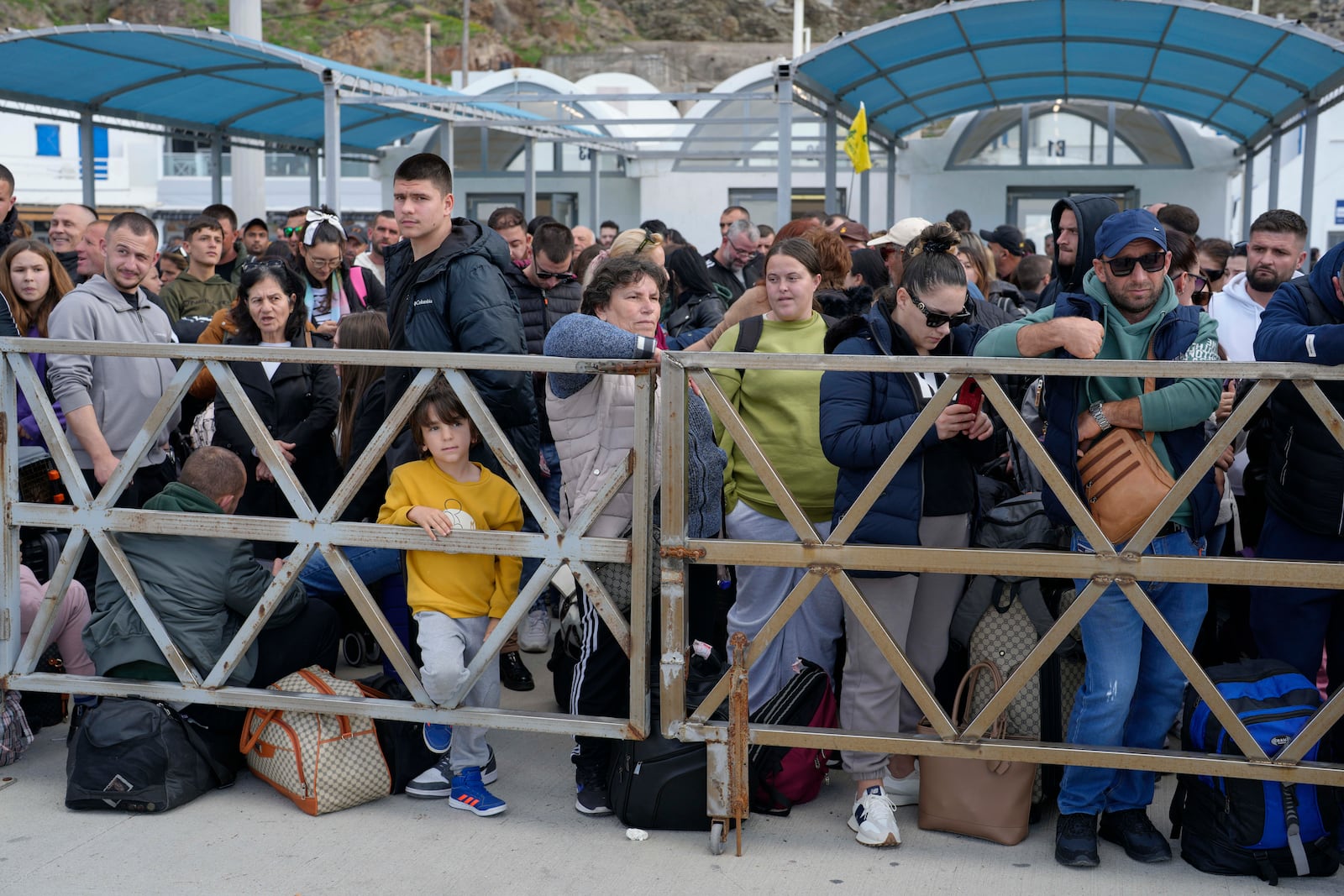 People wait for the arrival of a regularly scheduled ferry to Athens' port of Piraeus, after a spike in seismic activity raised concerns about a potentially powerful earthquake in Santorini, southern Greece, Monday, Feb. 3, 2025. (AP Photo/Petros Giannakouris)