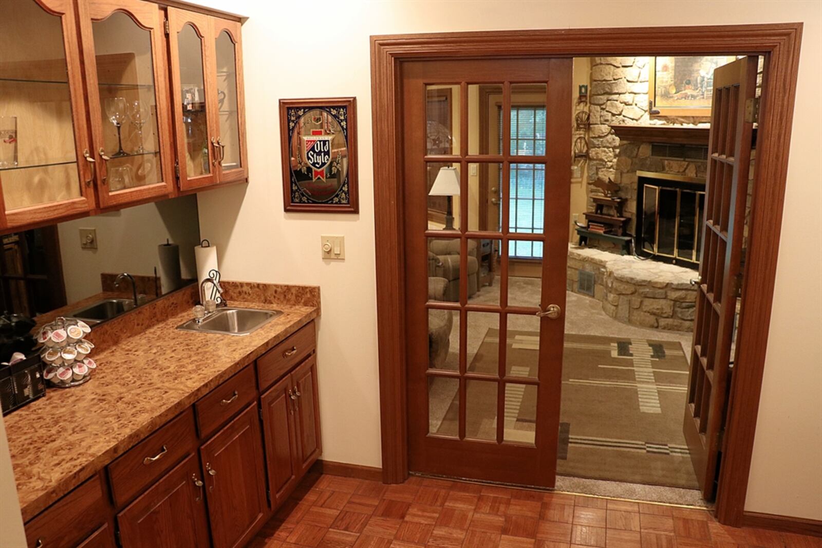 French doors open off the butler’s pantry into the spacious family room that stretches across the back of the house. Tucked into one corner is a stone fireplace. 