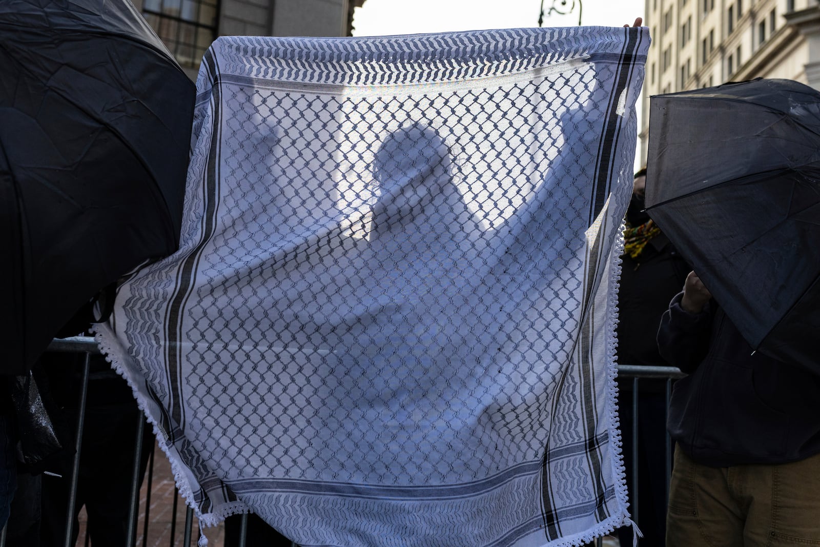 A student from Columbia University holds up a keffiyeh as they line up to enter Manhattan federal court to attend the deportation case of Mahmoud Khalil, Wednesday, March 12, 2025, in New York. (AP Photo/Stefan Jeremiah)