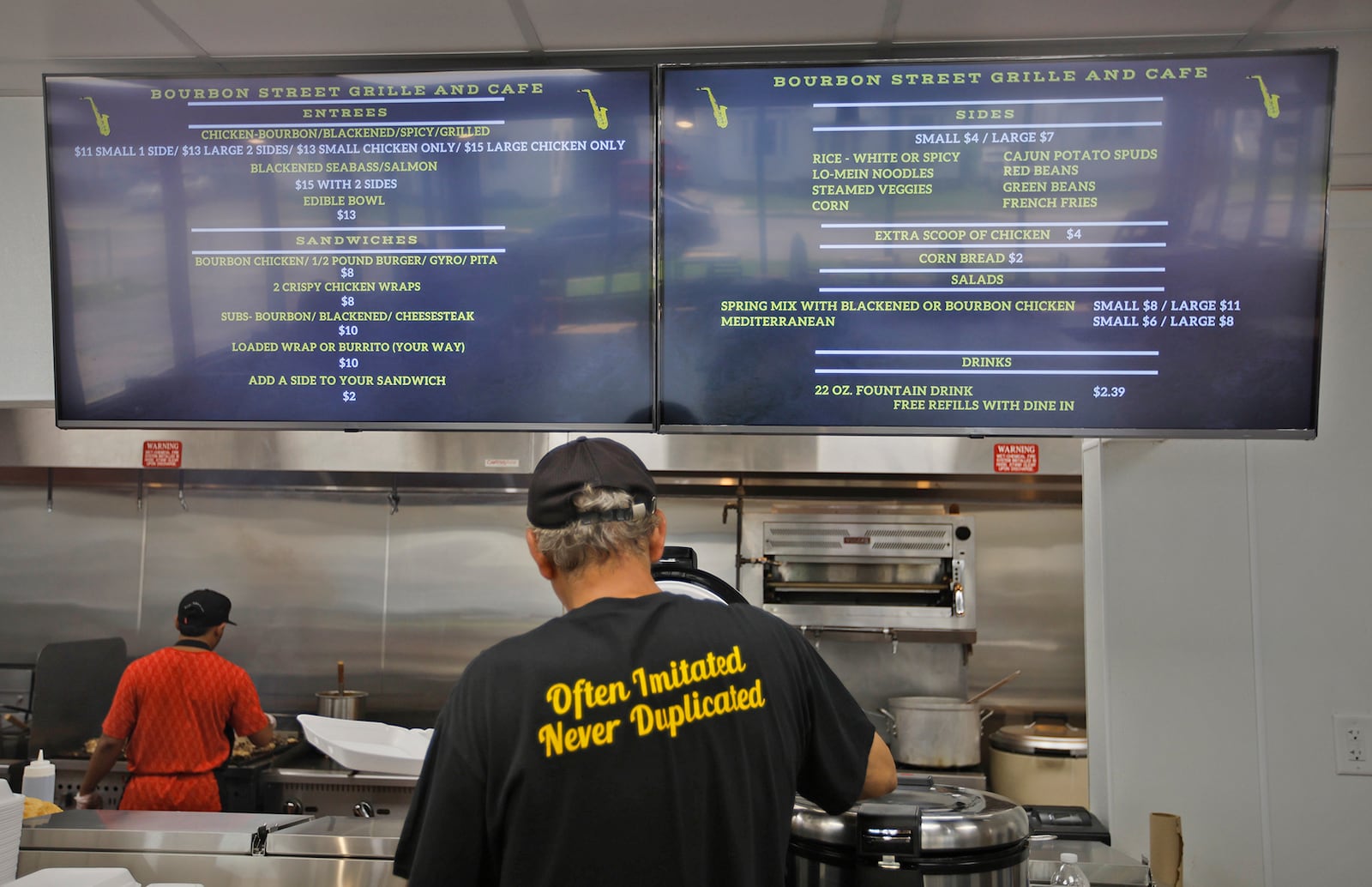 Hassan Abdalla, owner of the new Bourbon Street Grill & Cafe, works on a customer's order Monday, July 8, 2024. BILL LACKEY/STAFF