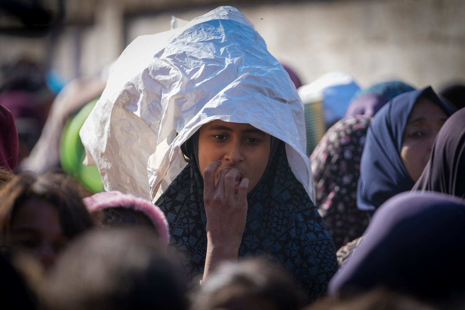 A Palestinian girl waits in line for food at a distribution center in Deir al-Balah, Gaza Strip, Tuesday, Dec. 17, 2024. (AP Photo/Abdel Kareem Hana)