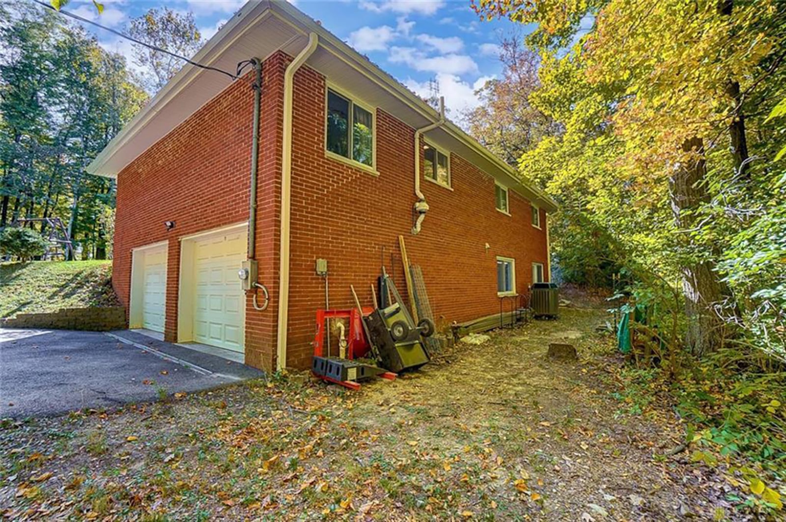 The rear of the home is lined with mature trees, and there are two sliding glass doors – one from the main bedroom to the fenced side yard and another from the partially finished basement to the rear yard. A 2-car, attached garage on the basement level. CONTRIBUTED PHOTO