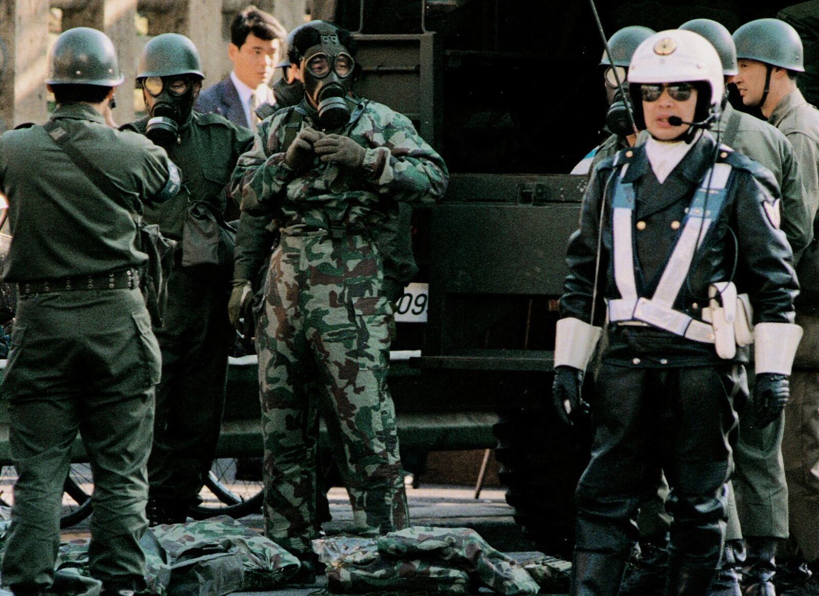 Ground Self Defense Force members wearing gas mask and protective suit stand by near a subway station where passengers were affected by sarin nerve gas in Tokyo on March 20, 1995. (Kyodo News via AP)