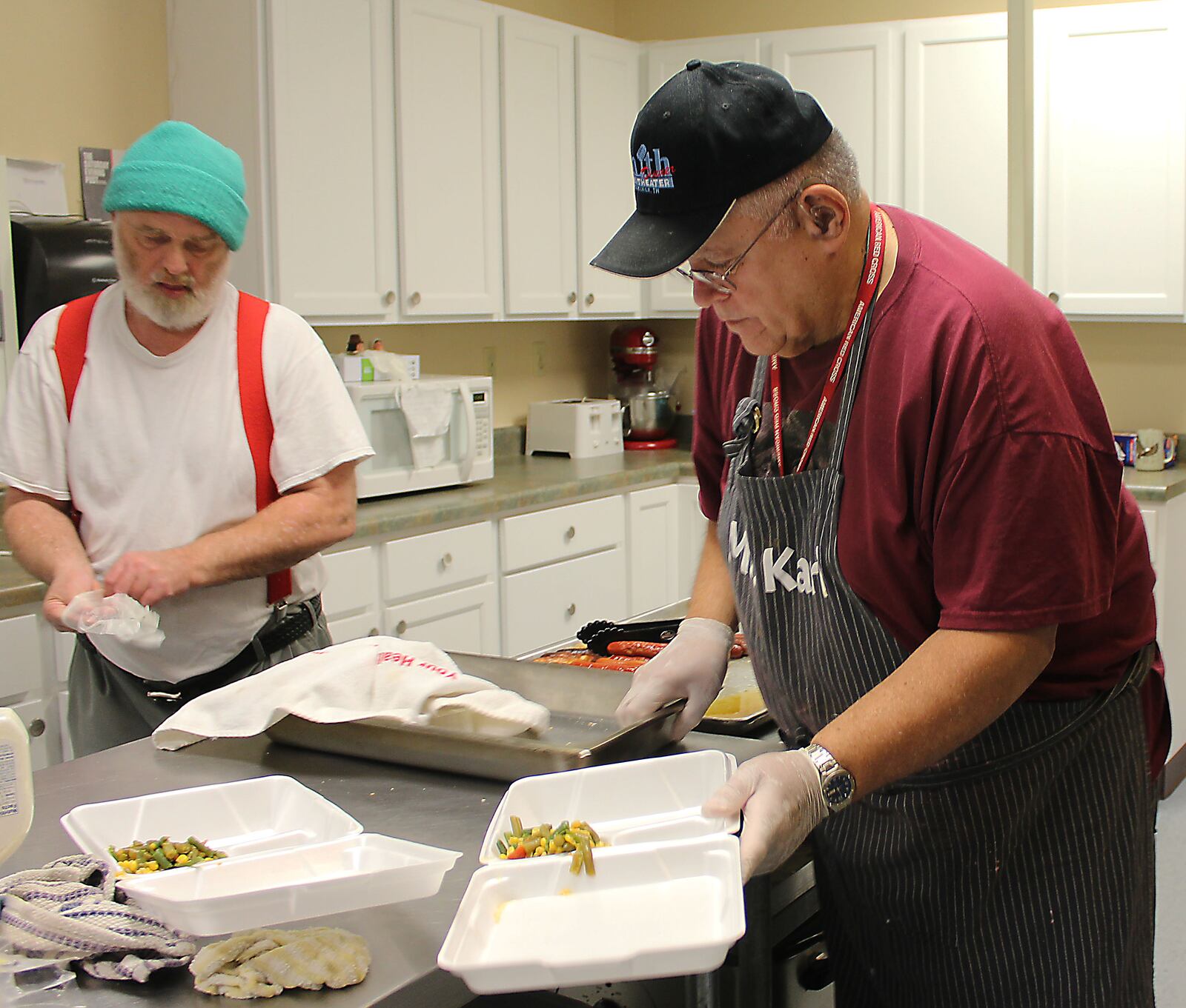 Caring Kitchen workers, (left) Donald Willson and Karl Zerkle get ready to serve lunches at the Urbana kitchen. JEFF GUERINI/STAFF