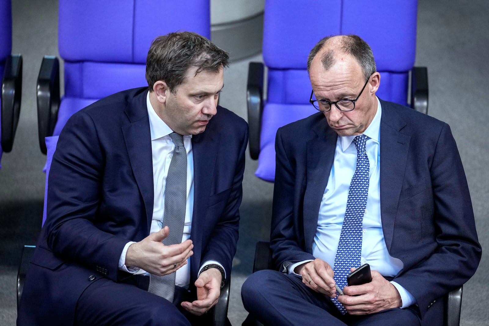 Friedrich Merz, leader of the Christian Democratic Union, right, and Social Democratic Party leader Lars Klingbeil talk during a meeting of the German federal parliament, Bundestag, at the Reichstag building in Berlin, Germany, Thursday, March 13, 2025. (AP Photo/Ebrahim Noroozi)