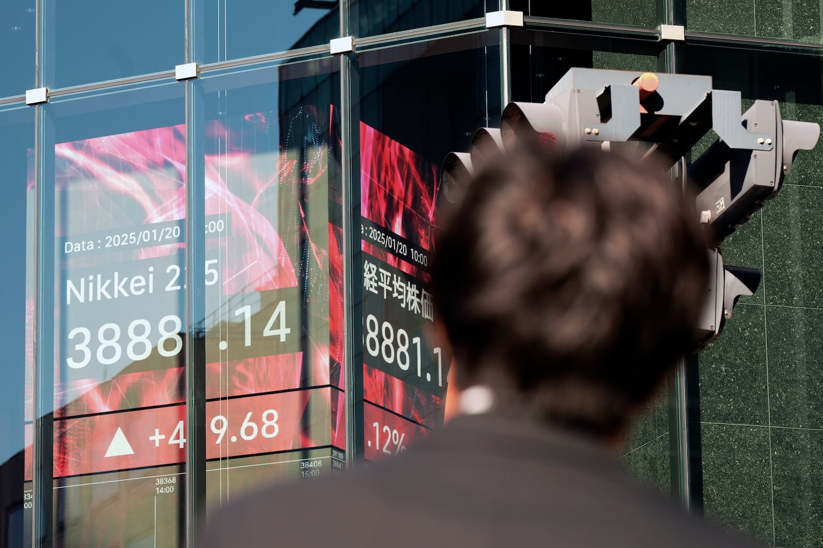 A person stands near an electronic stock board showing Japan's Nikkei index at a securities firm Monday, Jan. 20, 2025, in Tokyo. (AP Photo/Eugene Hoshiko)