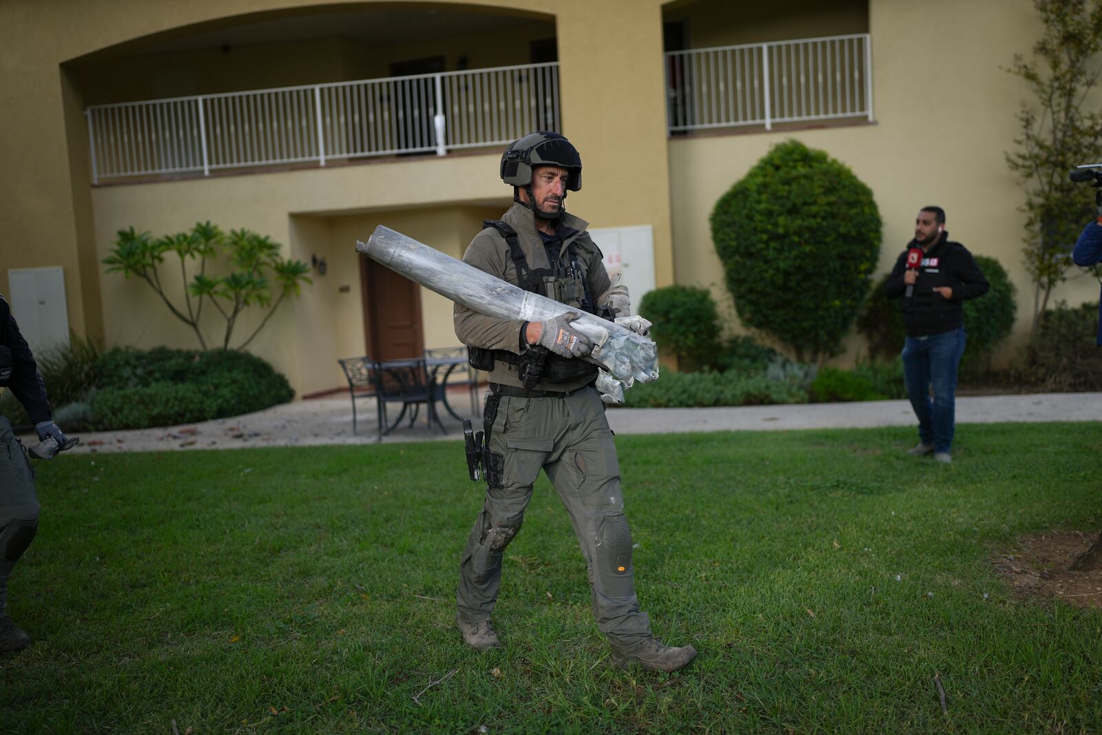 An Israeli bomb squad policeman carries the remains of a rocket that was fired from Lebanon in Kibbutz Kfar Blum, northern Israel Sunday Nov. 24, 2024. (AP Photo/Ohad Zwigenberg)