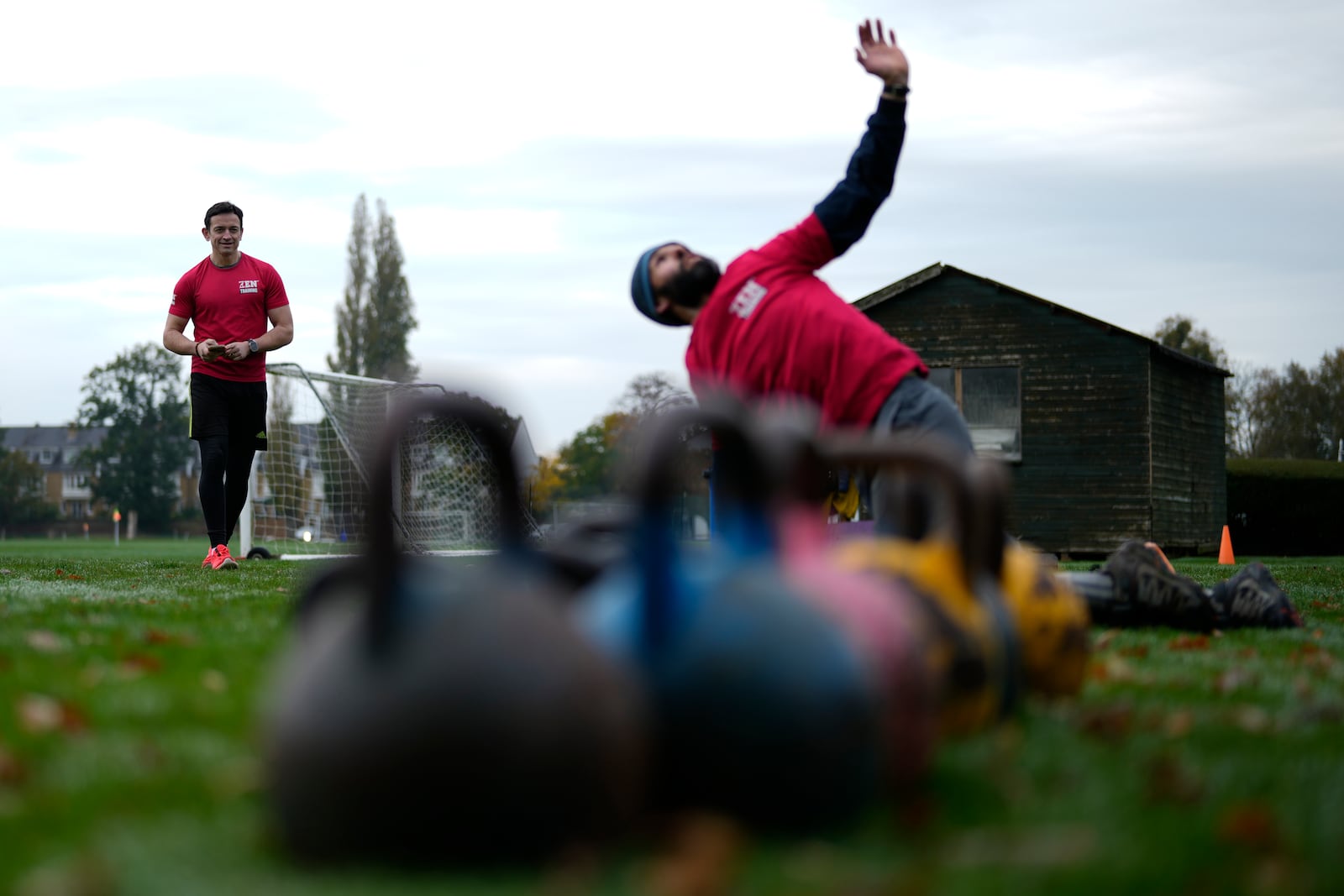 Owner of a personal fitness company Zen Training, Alan Ezen, left, watches his trainer Richard Lamb, lead an outdoor gym class in London, Saturday, Oct. 26, 2024. (AP Photo/Alastair Grant)