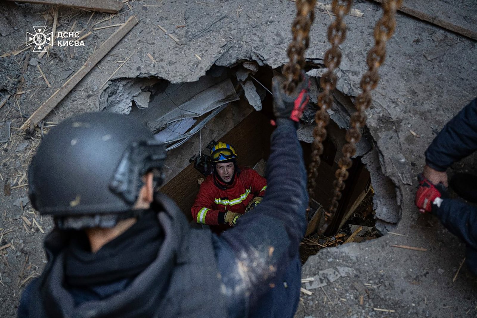 In this photo provided by the Ukrainian Emergency Service, emergency services personnel remove part of a Russian missile that hit an apartment house during massive missile attack in Kyiv, Ukraine, Sunday, Nov. 17, 2024. (Ukrainian Emergency Service via AP)