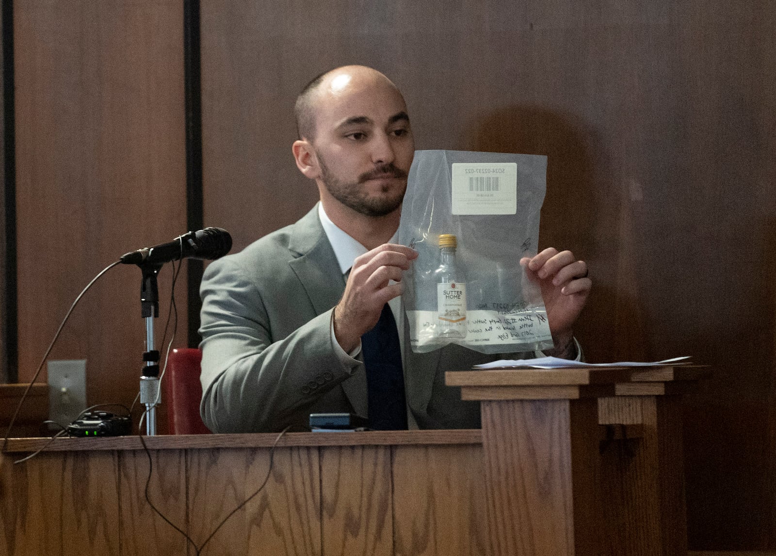 Deputy Alec Preadmore of traffic services for the Monroe County Sheriff's Department, holds evidence during the trial of Marshella Chidester at the Monroe County Courthouse, Thursday, March 6, 2025, in Monroe, Mich. (Mandi Wright/Detroit Free Press via AP)